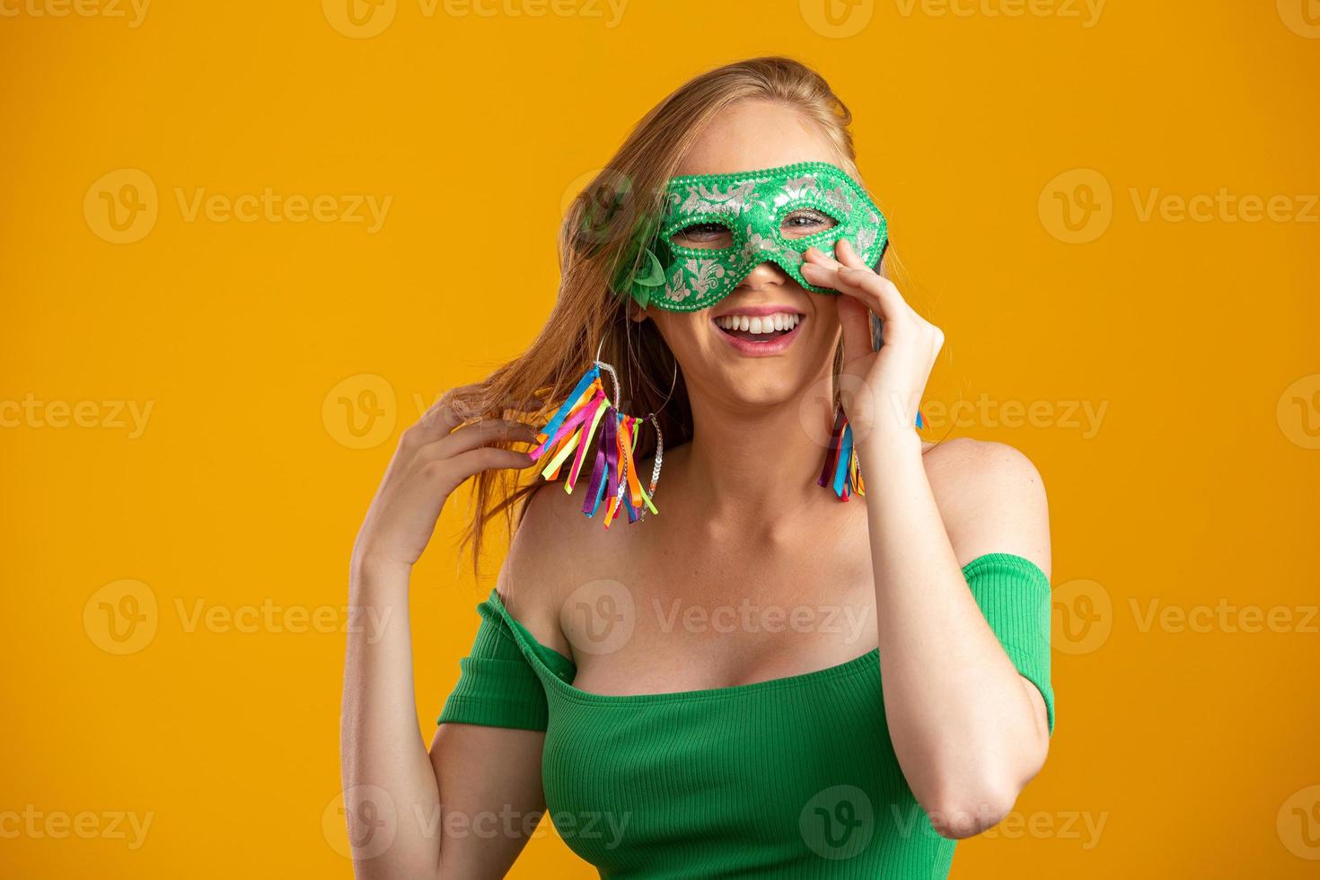 hermosa mujer vestida para la noche de carnaval. mujer sonriente lista para disfrutar del carnaval con una máscara colorida. foto