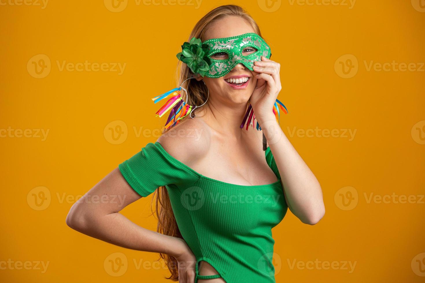 Beautiful woman dressed for carnival night. Smiling woman ready to enjoy the carnival with a colorful mask. photo