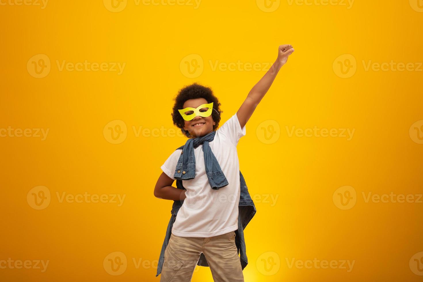 Portrait of a young, mixed race boy dressed as a superhero. Black baby in super hero costume. The winner and success concept. photo