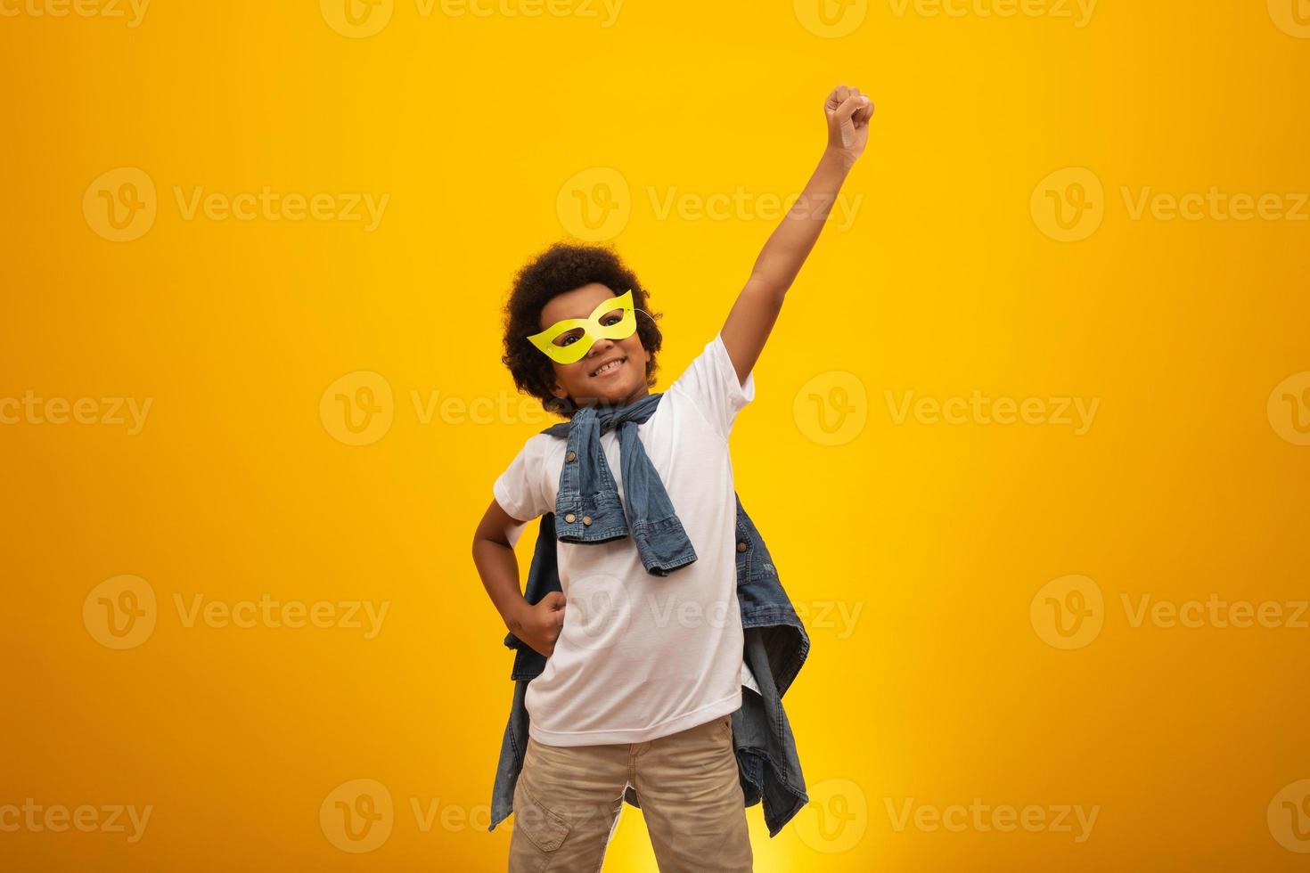 Portrait of a young, mixed race boy dressed as a superhero. Black baby in super hero costume. The winner and success concept. photo