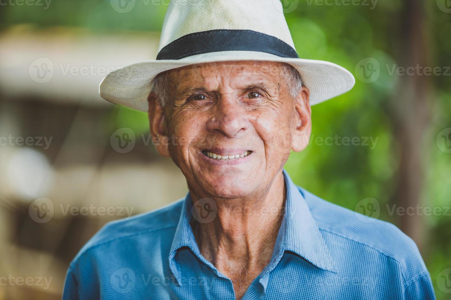 Portrait of smiling beautiful older male farmer. Elderly man at farm in summer day. Gardening activity. Brazilian elderly man. photo