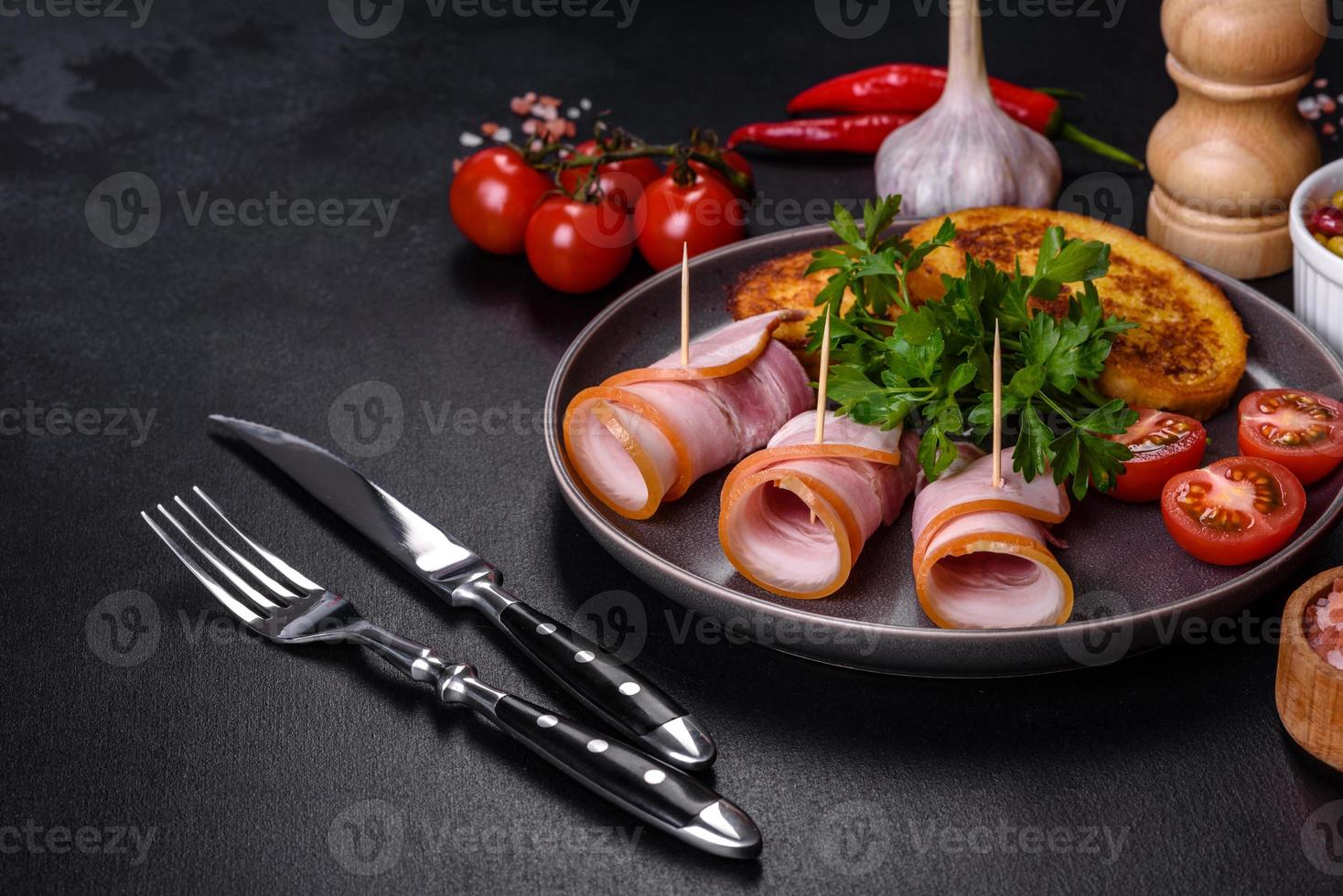 Slices of delicious raw or salted bacon with spices, salt, vegetables and herbs on a wooden cutting board photo