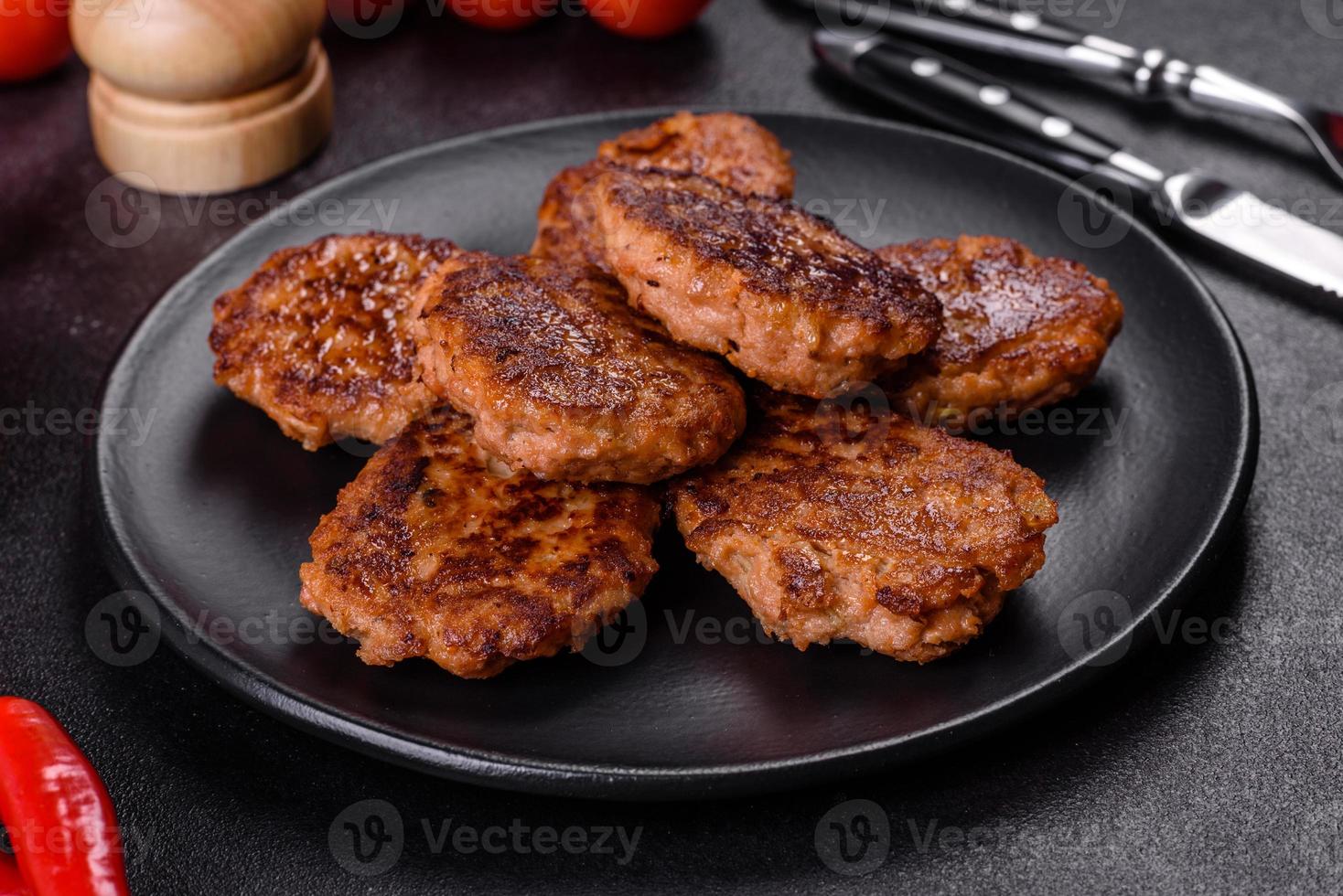 Fish cakes. Fish patties. Fried cutlets of minced fish on a black plate photo