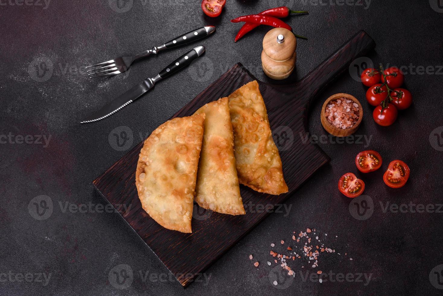 Homemade chebureks filled with minced meat and onions, traditional Caucasian cuisine photo