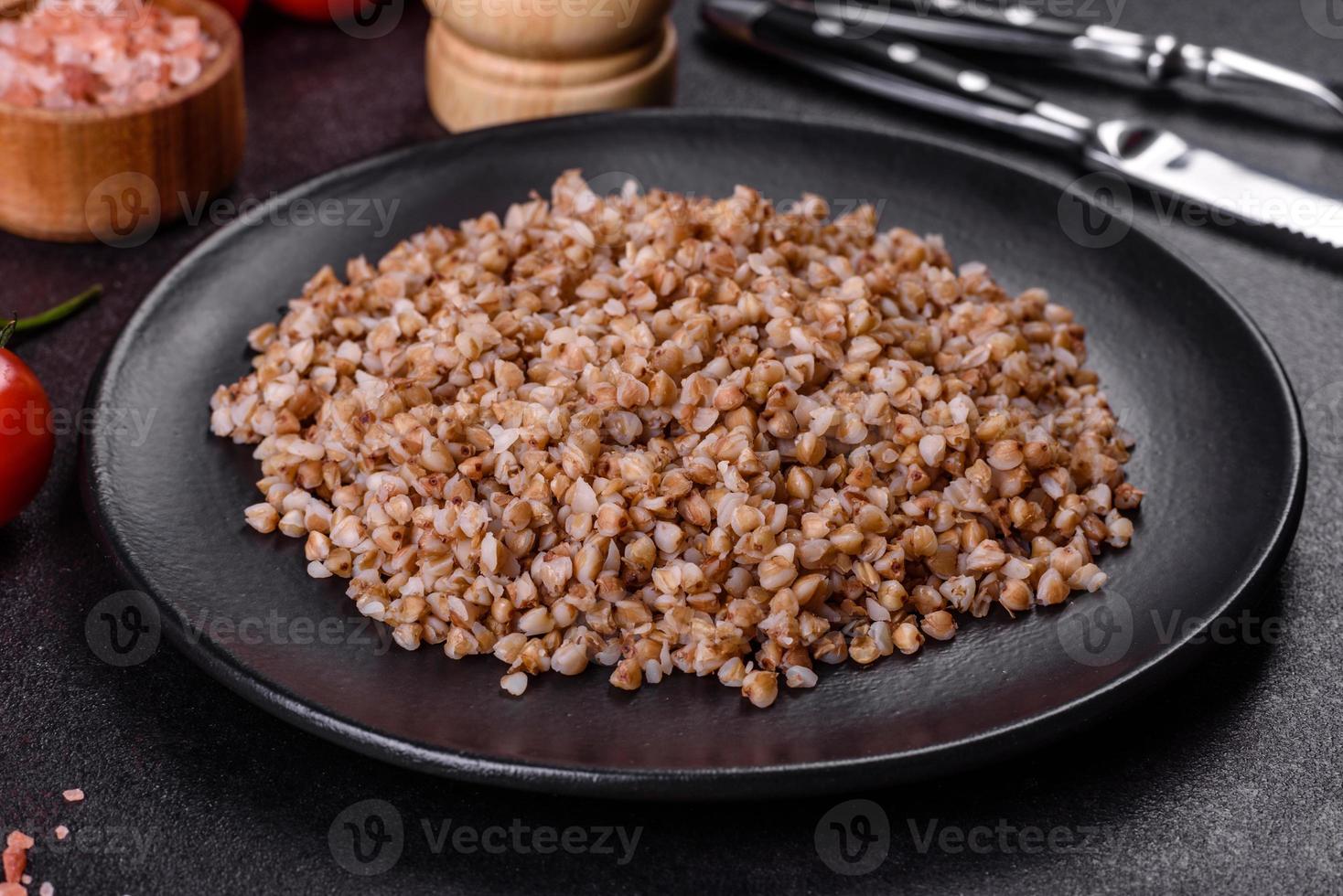 deliciosas gachas de trigo sarraceno recién hervidas con verduras y especias en un plato negro foto