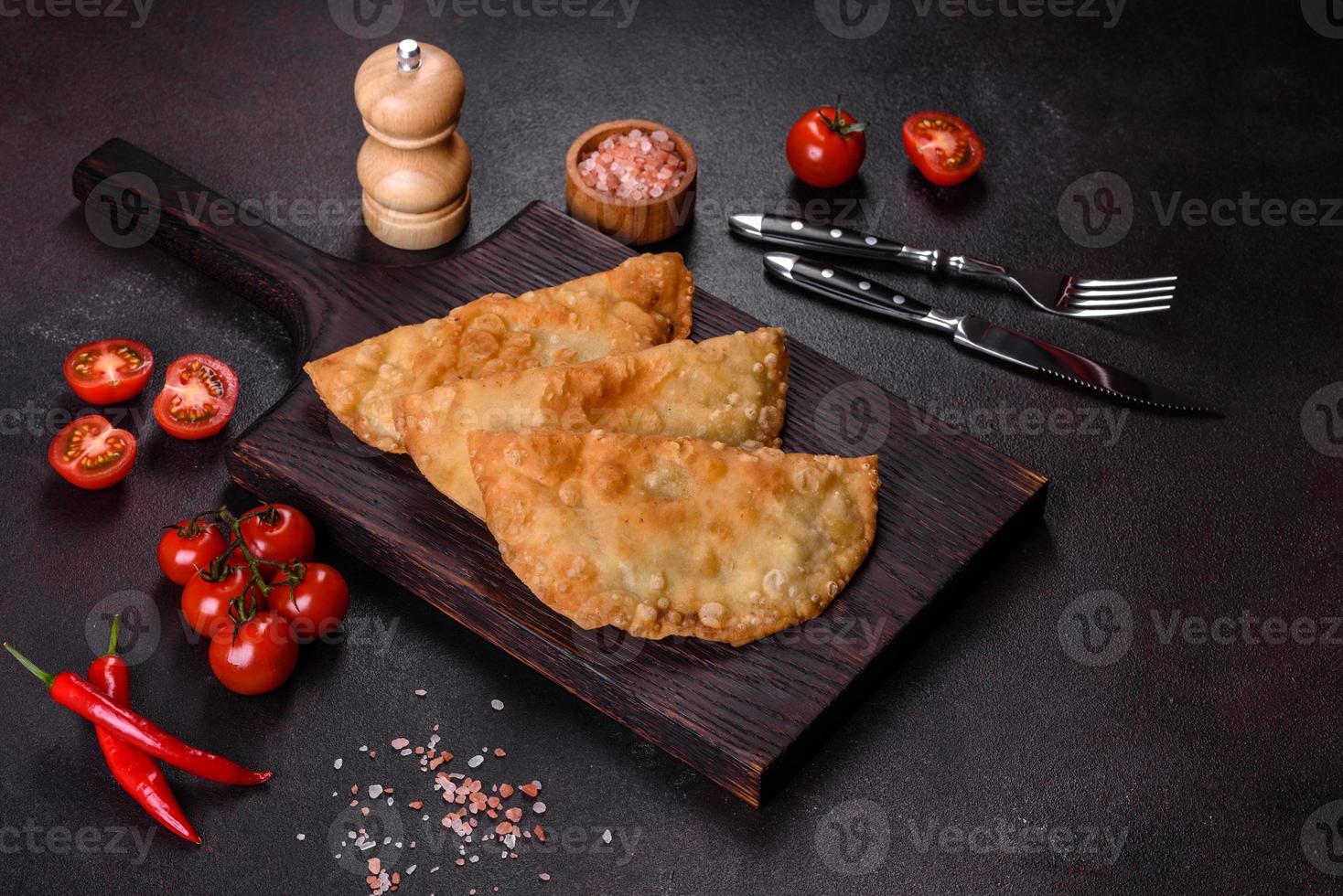 Homemade chebureks filled with minced meat and onions, traditional Caucasian cuisine photo