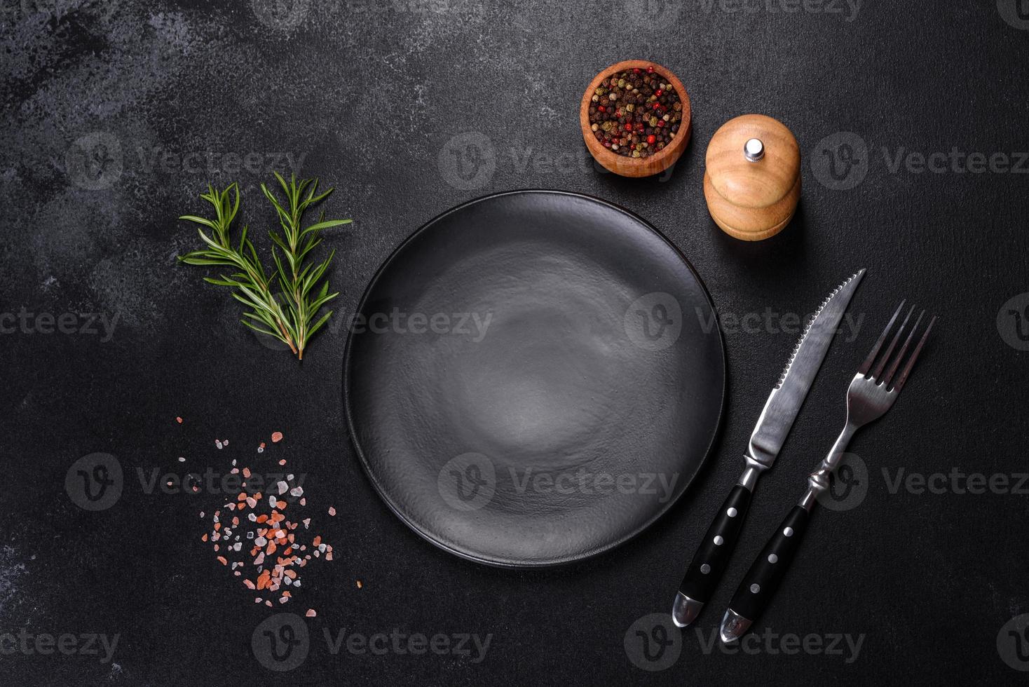 Empty round black plate on dark moody black background with copy space photo