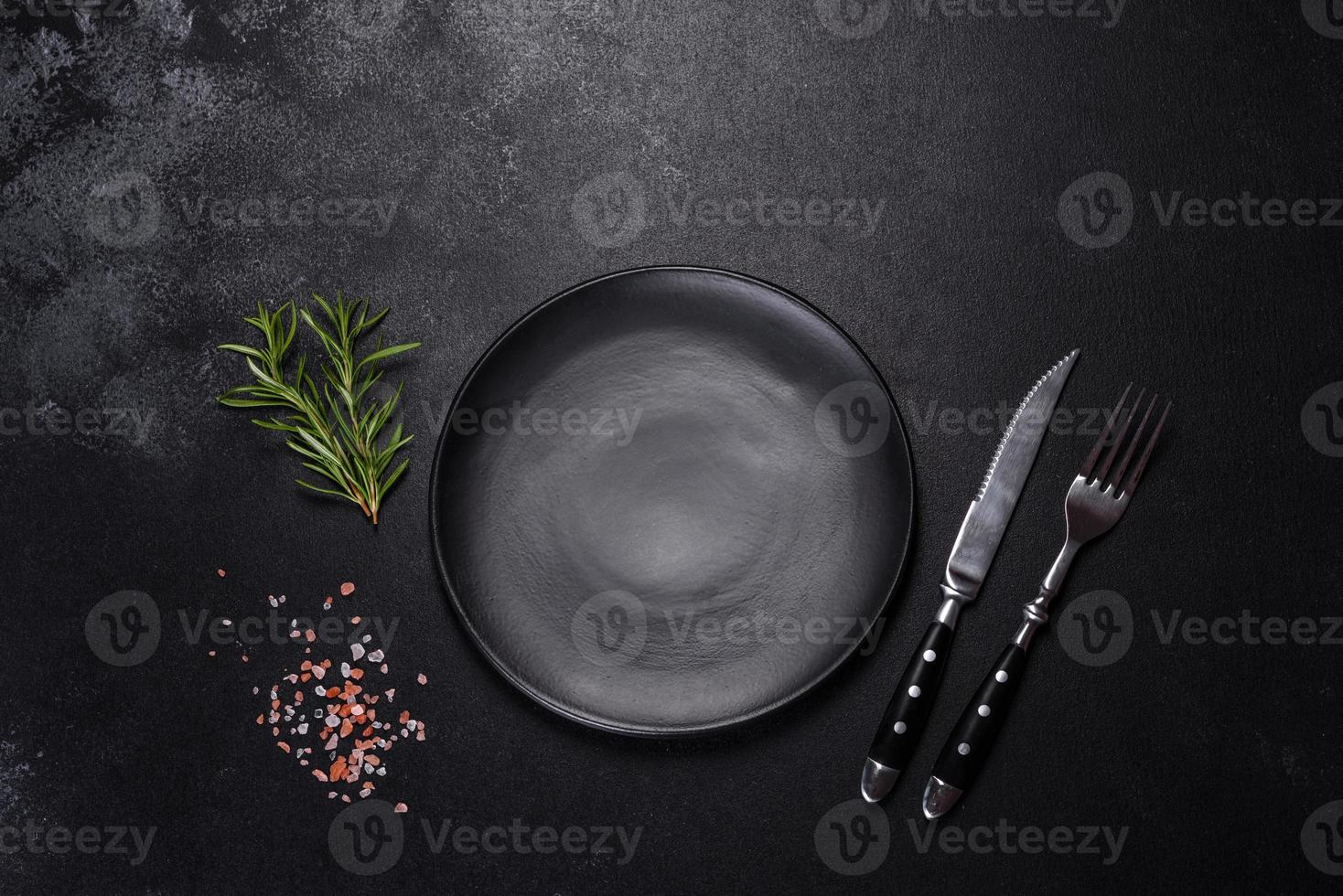 Empty round black plate on dark moody black background with copy space photo