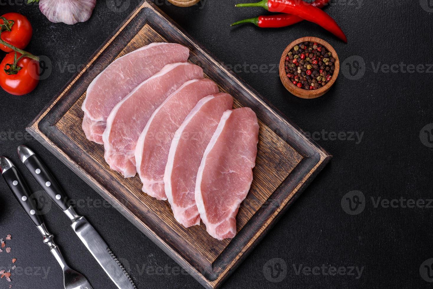 Raw fresh pork meat sliced on a wooden cutting board photo