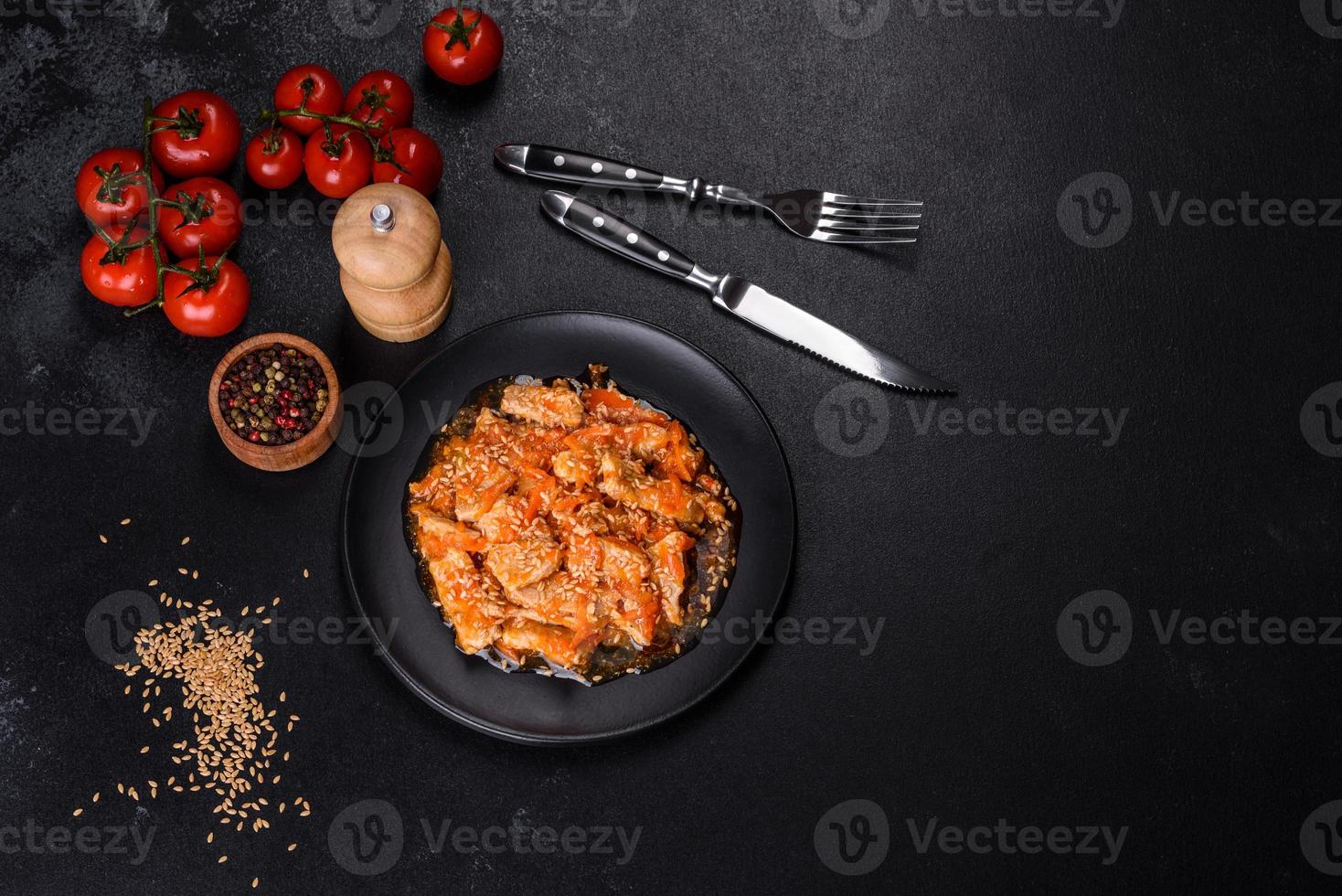 Teriyaki chicken with sauce, sesame, herbs and spices on a dark background photo