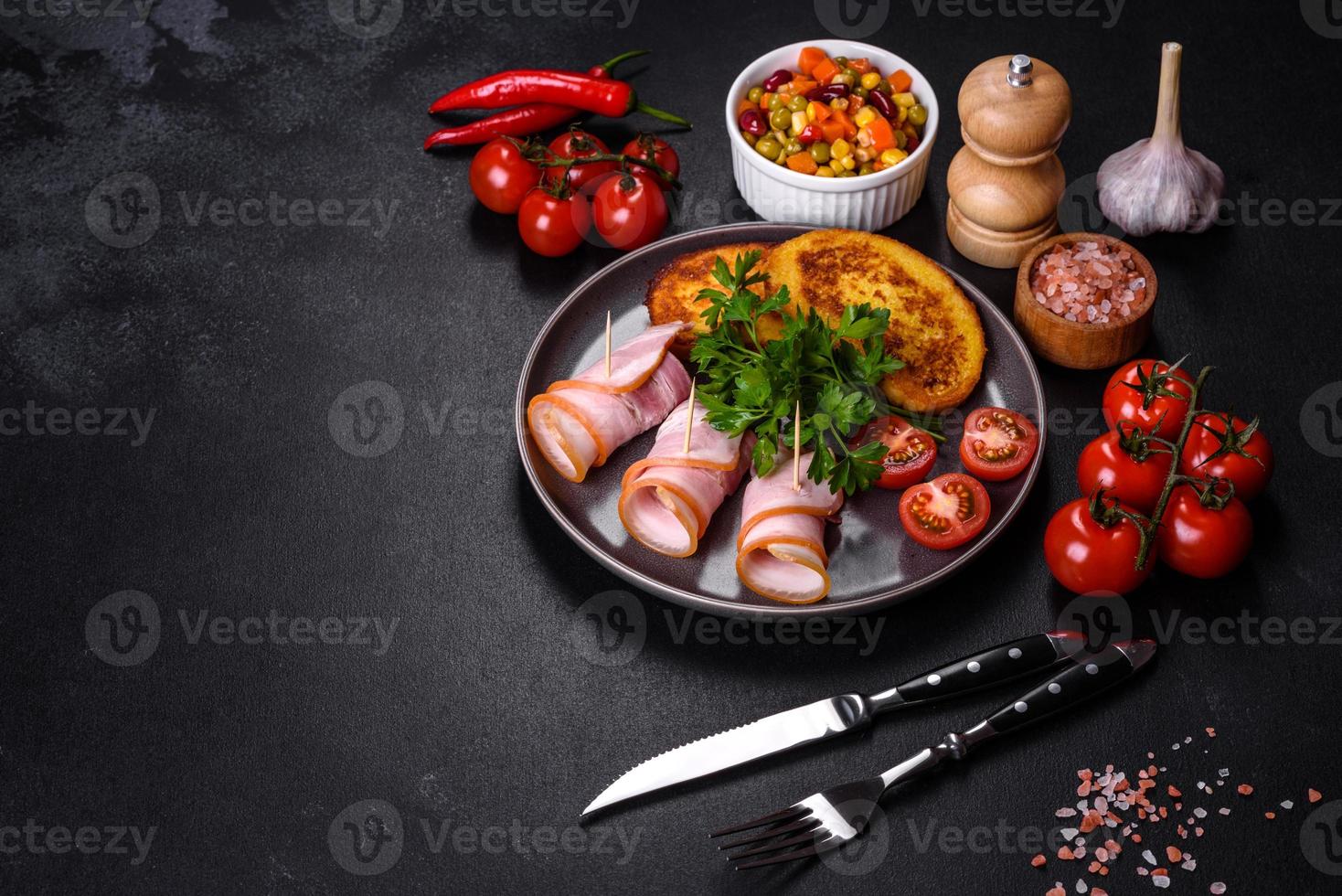 Slices of delicious raw or salted bacon with spices, salt, vegetables and herbs on a wooden cutting board photo