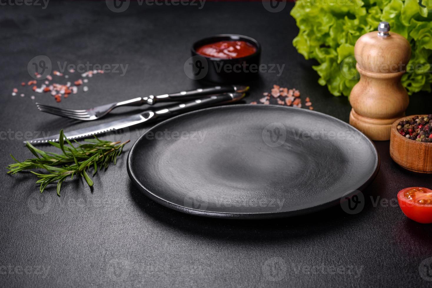 Empty round black plate on dark moody black background with copy space photo