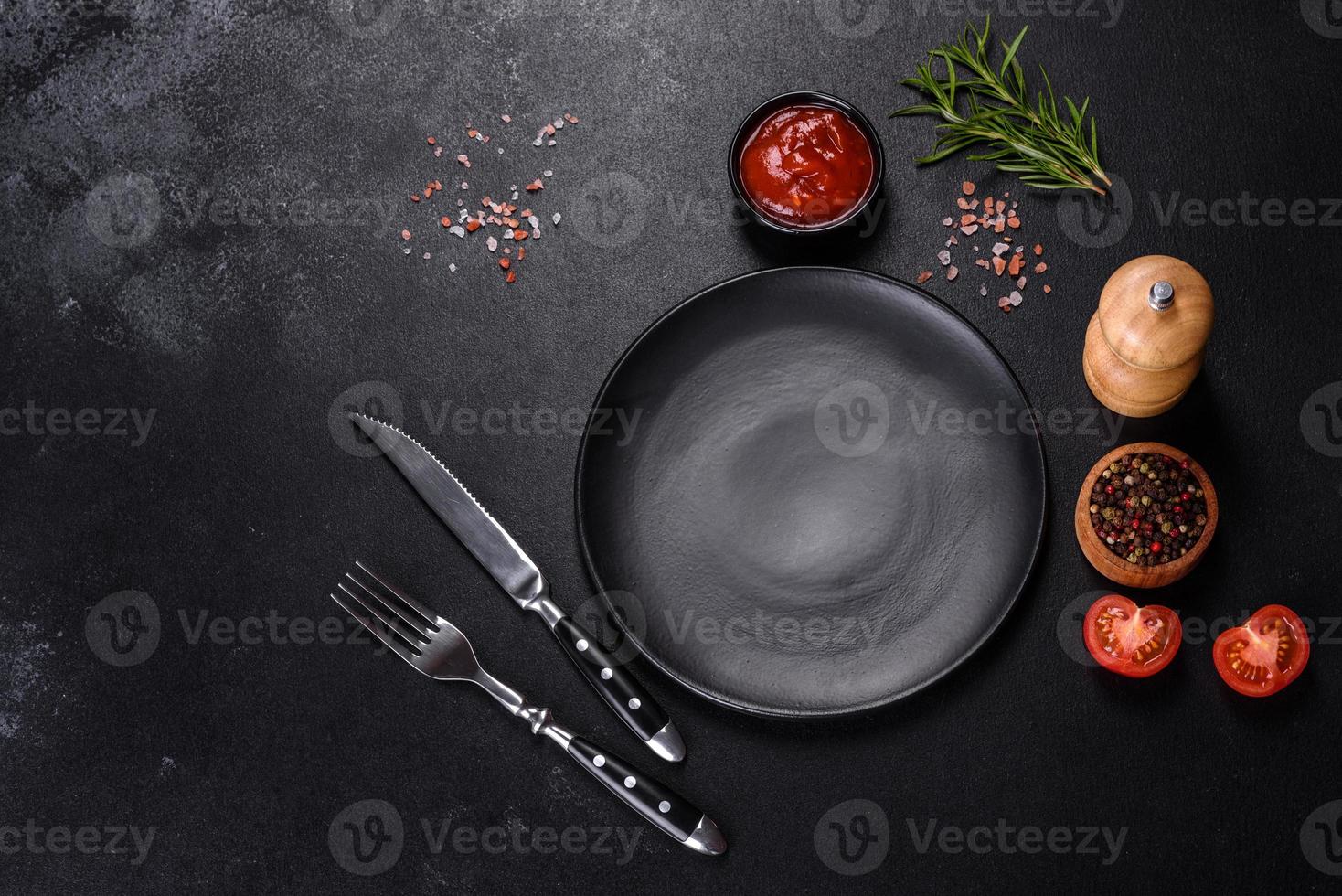 Empty round black plate on dark moody black background with copy space photo