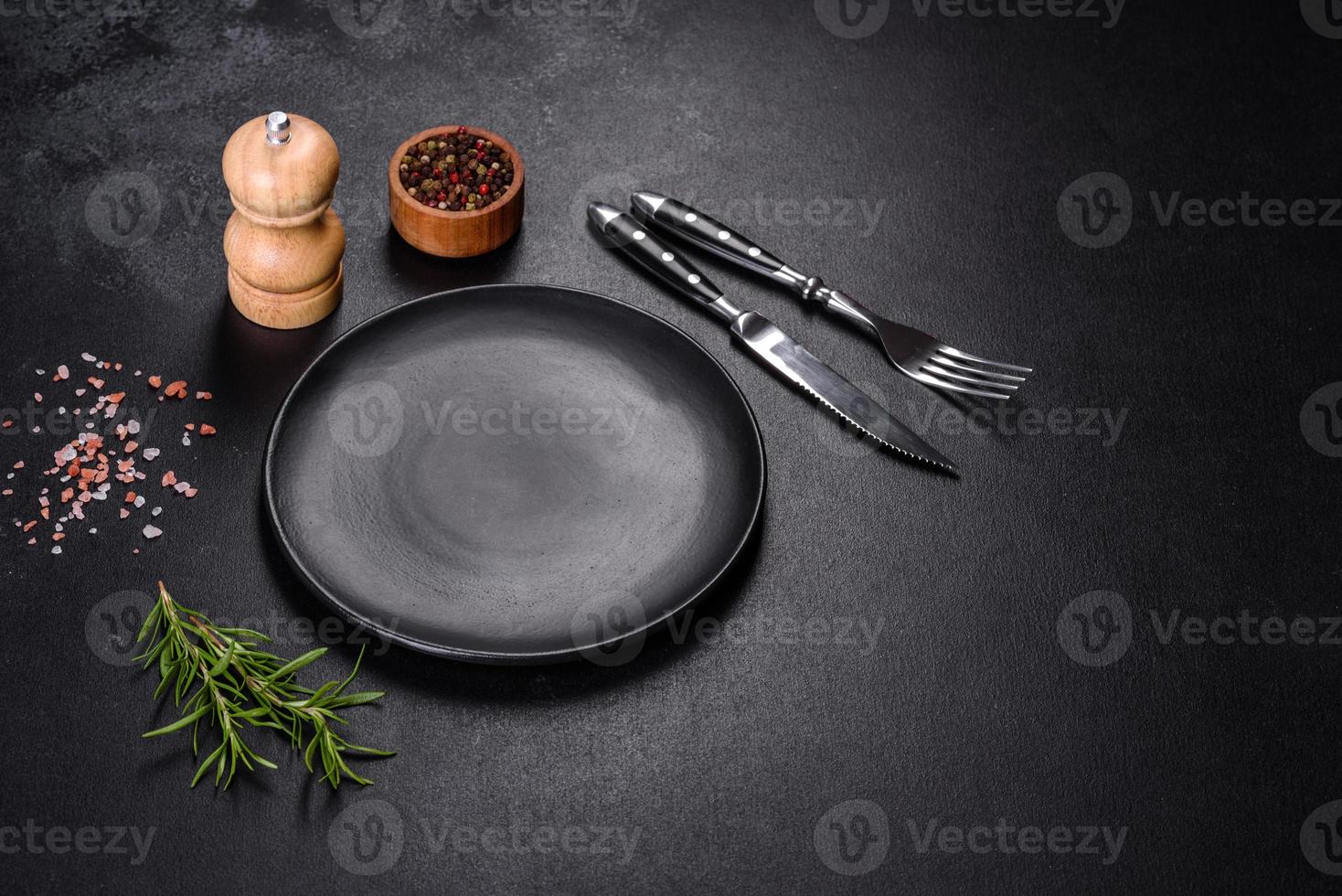 Empty round black plate on dark moody black background with copy space photo