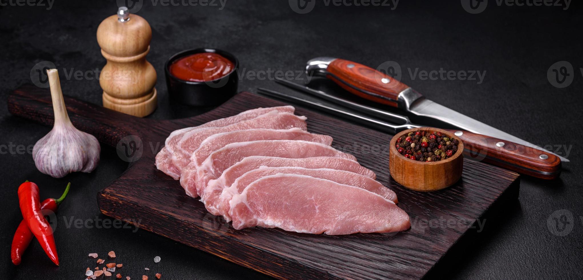 carne de cerdo fresca cruda cortada en una tabla de cortar de madera foto