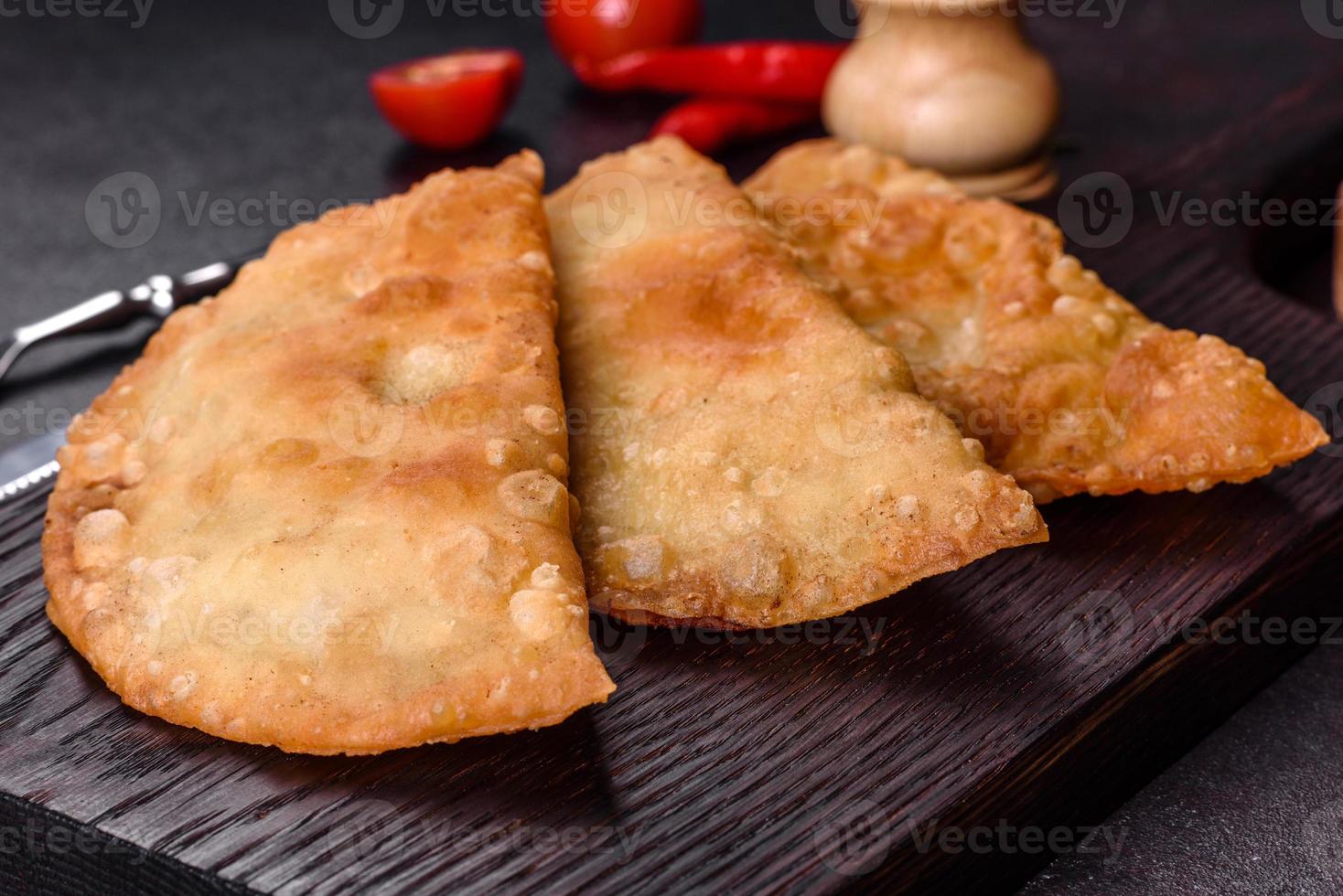 Homemade chebureks filled with minced meat and onions, traditional Caucasian cuisine photo