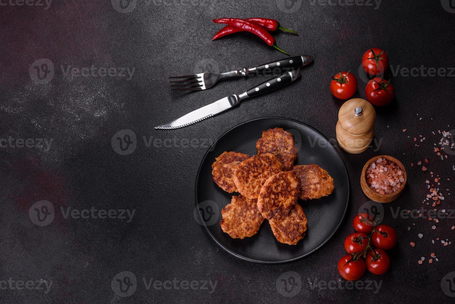 Fish cakes. Fish patties. Fried cutlets of minced fish on a black plate photo