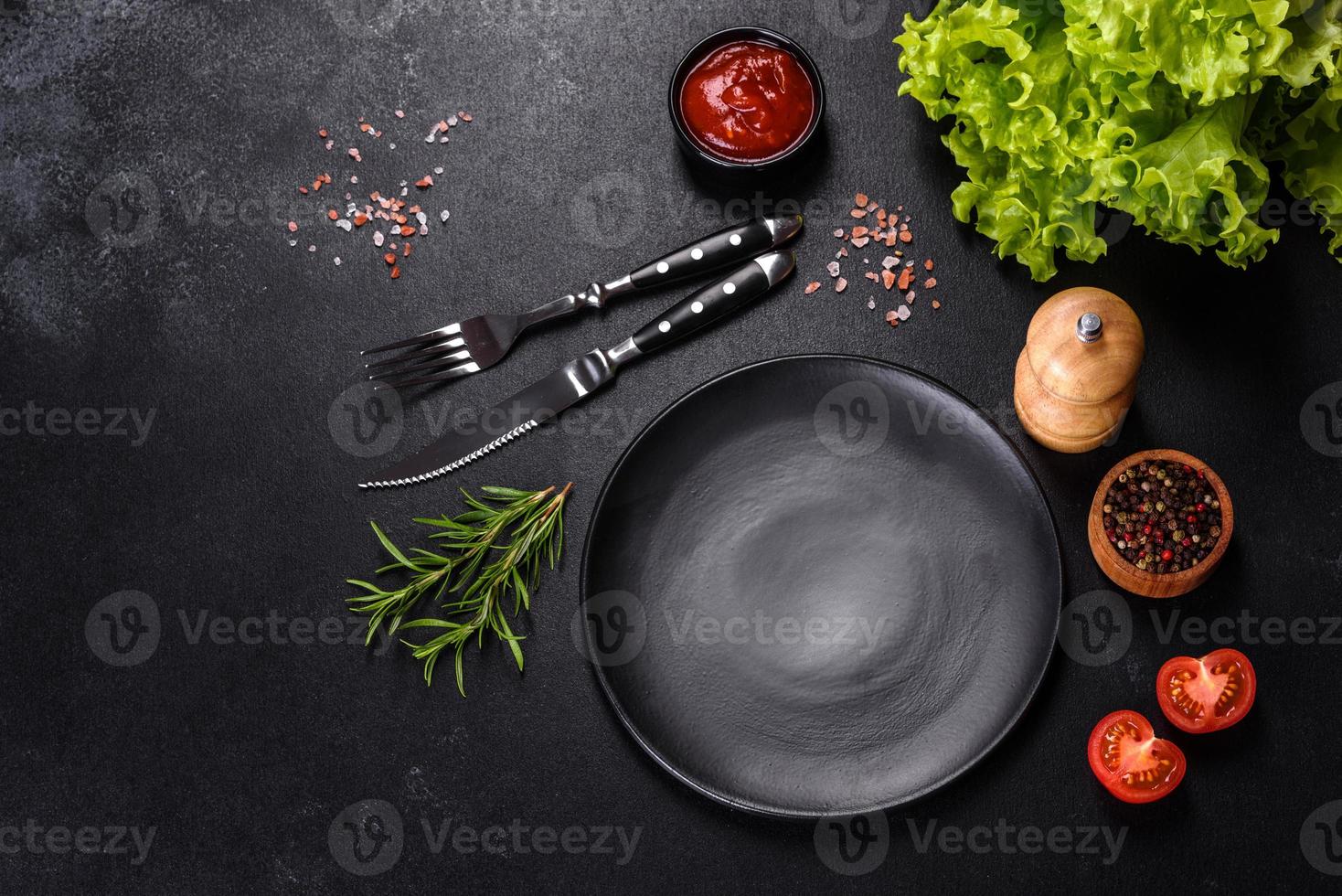 Empty round black plate on dark moody black background with copy space photo