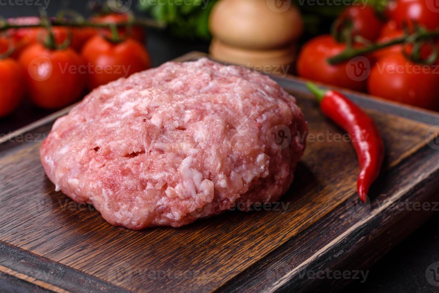 carne molida con ingredientes para cocinar sobre fondo negro foto