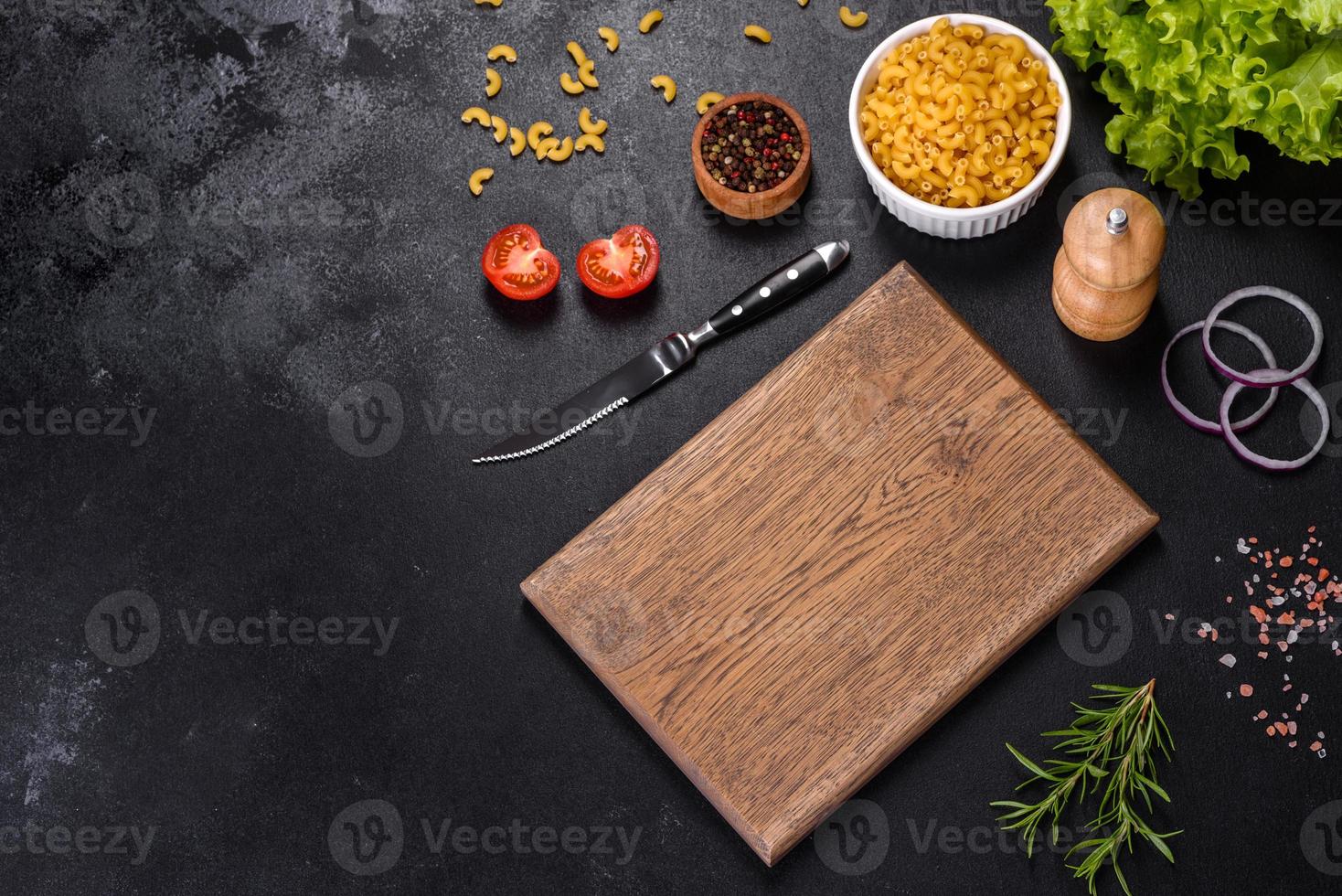 A wooden cutting board with a kitchen knife with spices and herbs photo