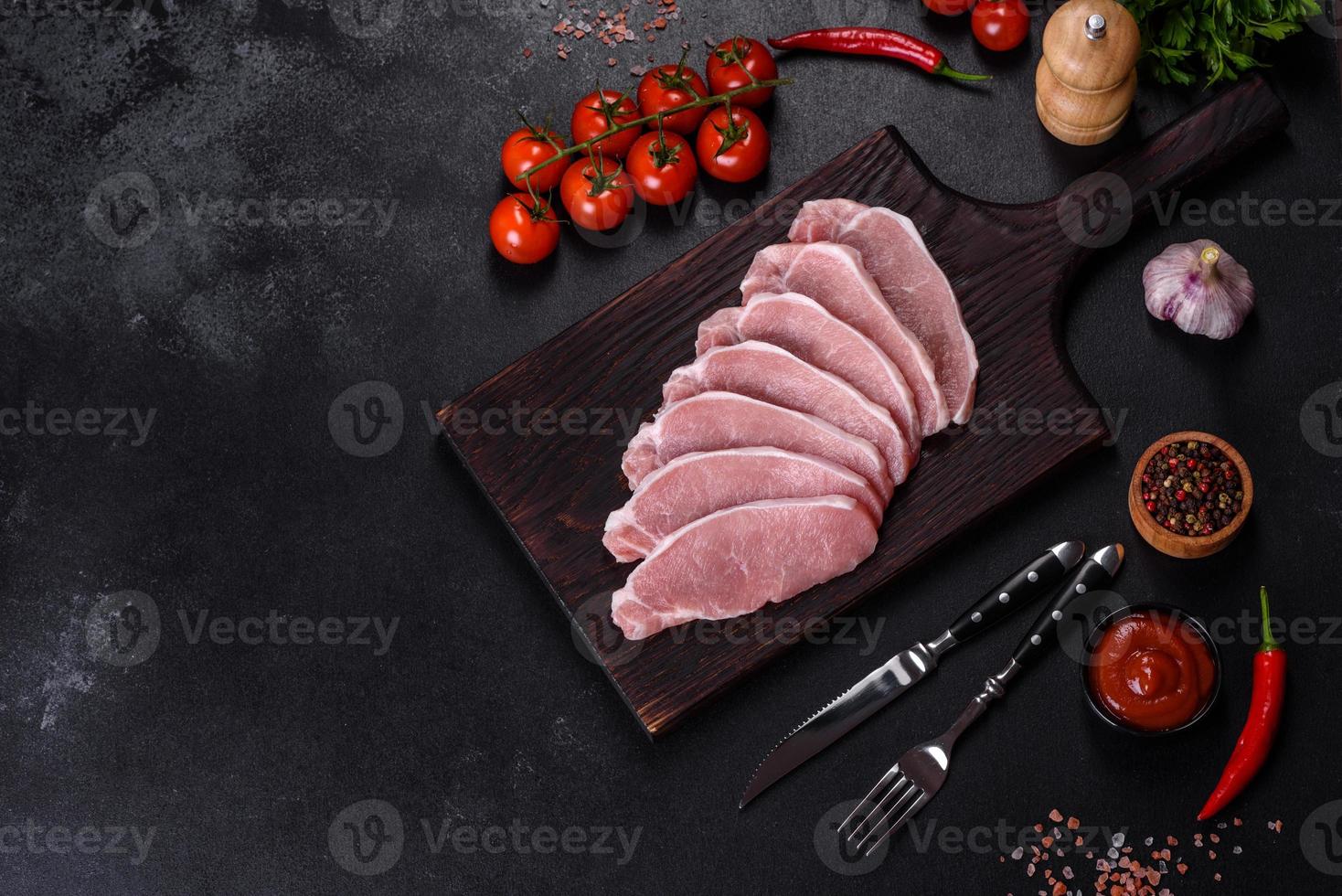 carne de cerdo fresca cruda cortada en una tabla de cortar de madera foto