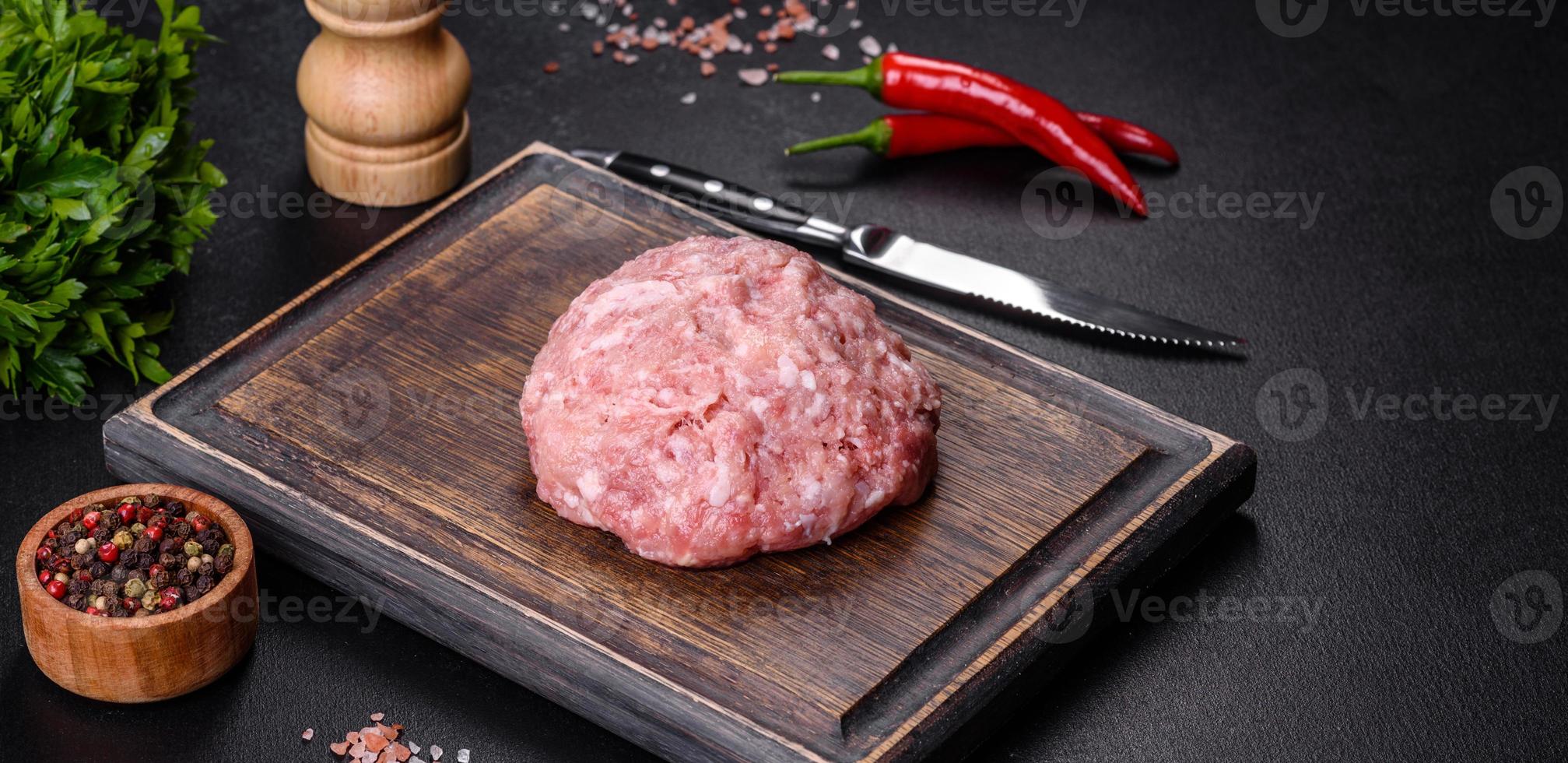 Ground meat with ingredients for cooking on black background photo