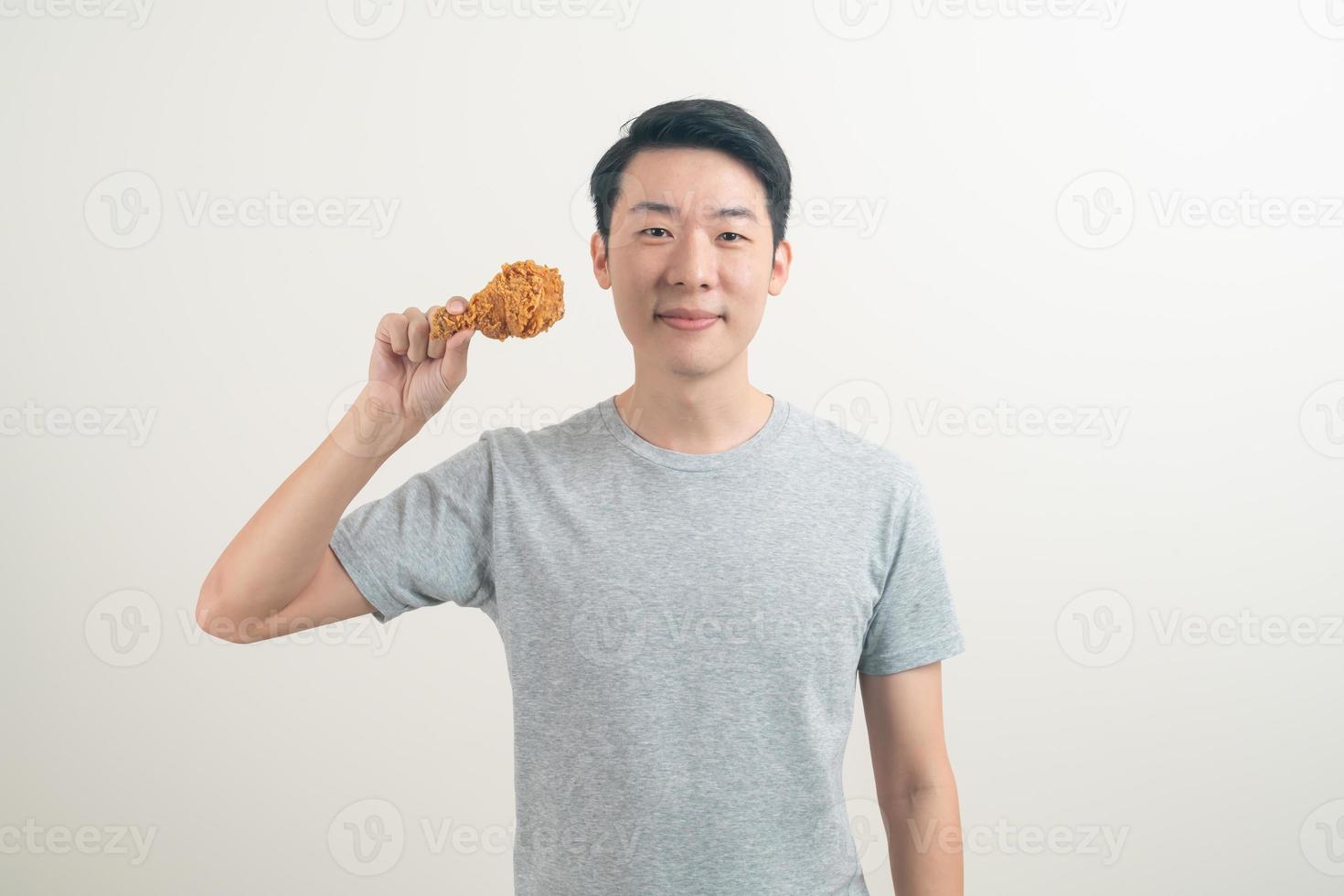 young Asian man with fried chicken on hand photo