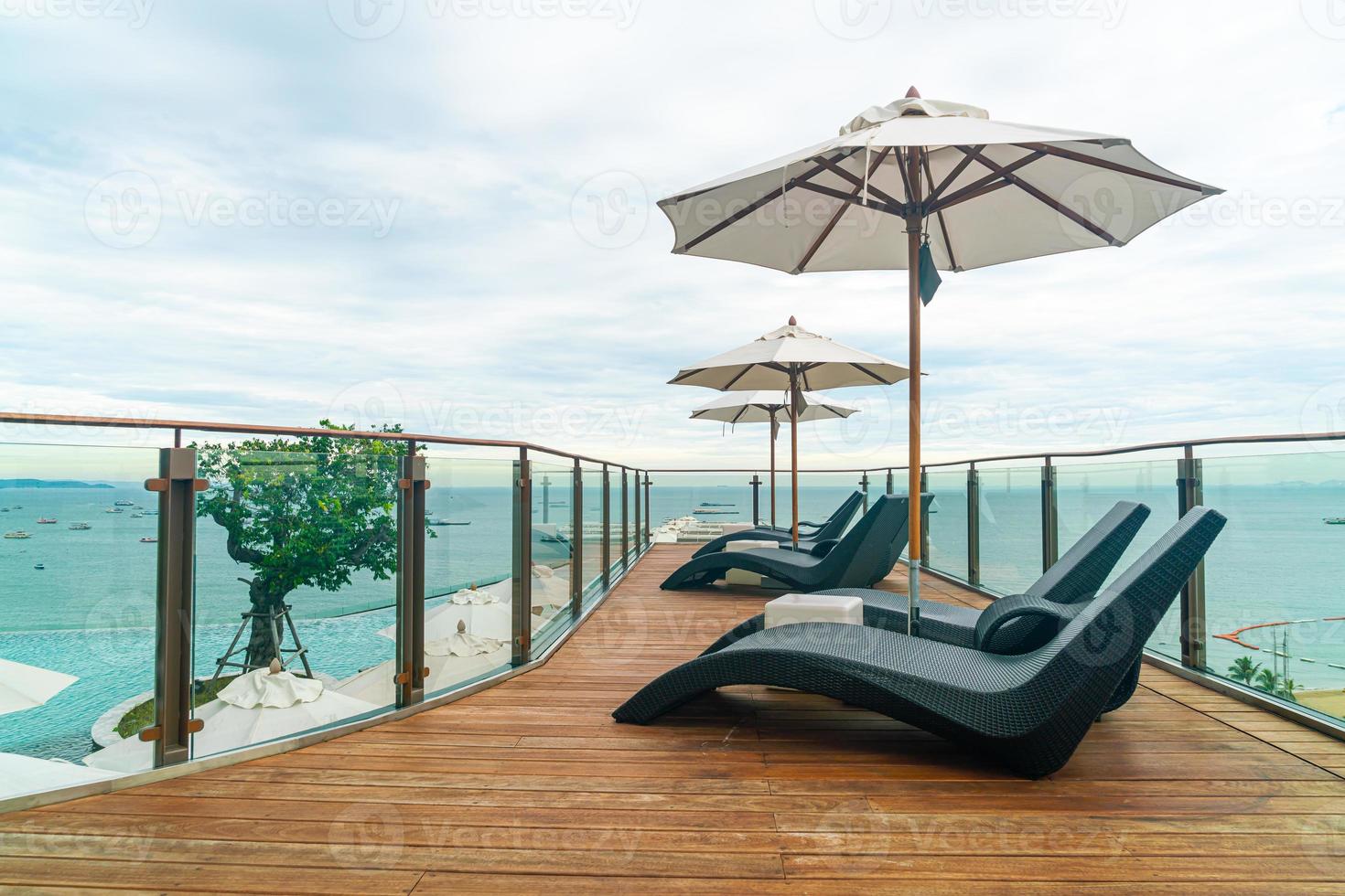 bed pool with umbrella around swimming pool photo