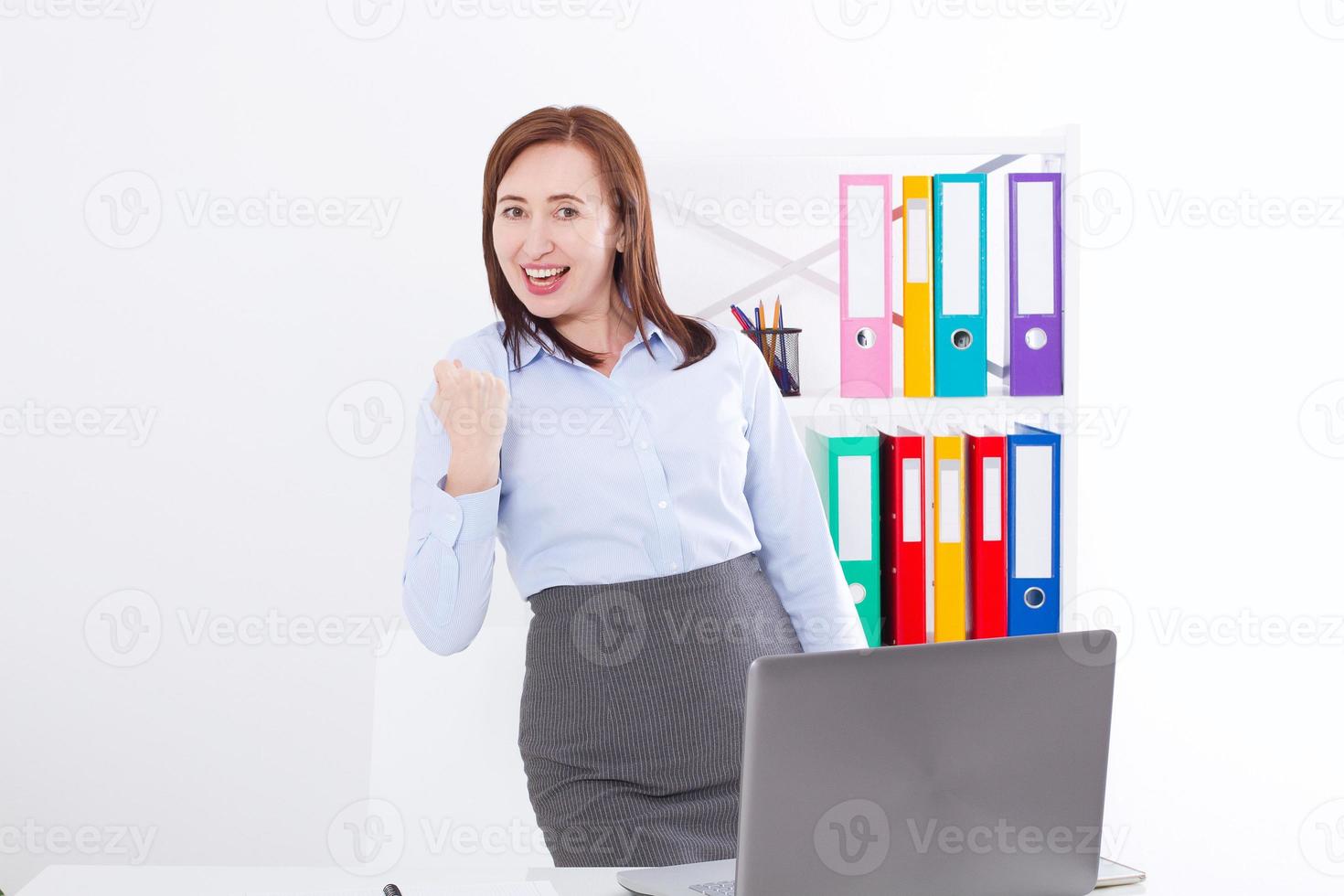 Happy and successful businesswoman raising her arm at office background and celebrating success at office background. mock up and copy space. Business concept photo