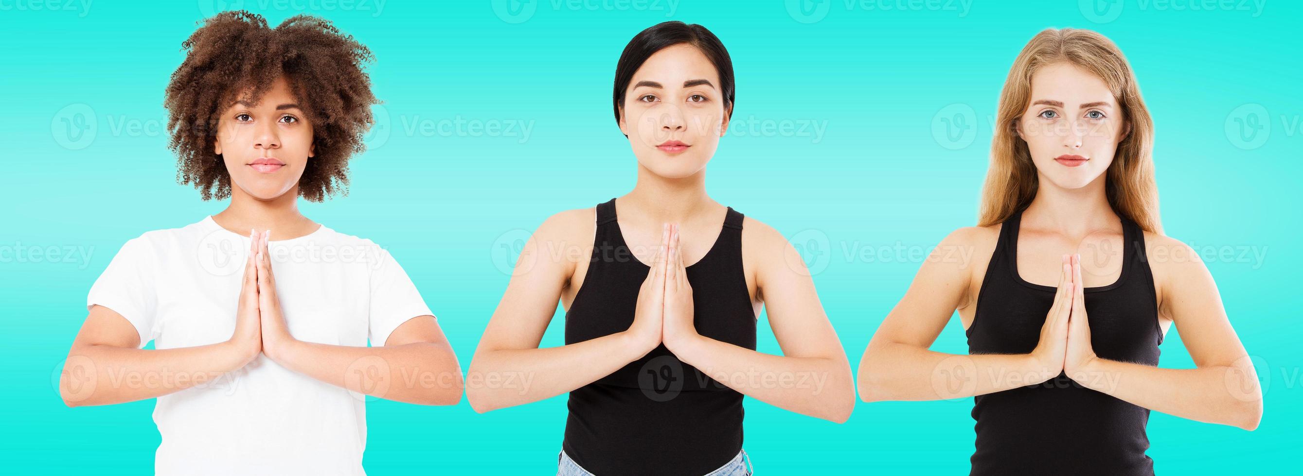 three smiling multiracial women with different types of skin caucasian, african american and asian girls in namaste pose isolated on blue background,beauty photo