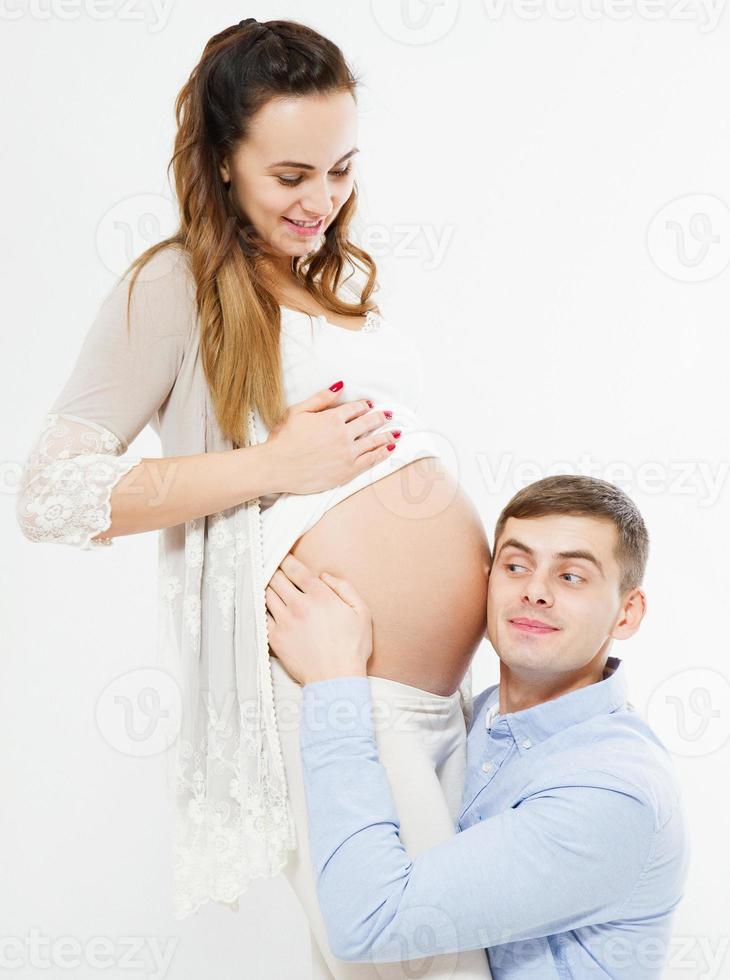 hombre escuchando el vientre embarazado de su esposa, bebé nacido foto