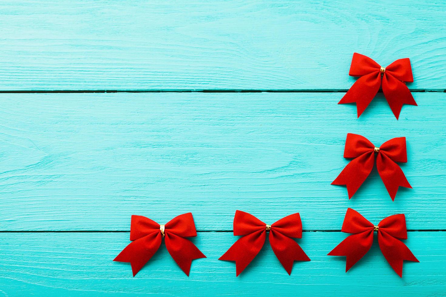 Frame of red bows on blue wooden background with copy space. photo