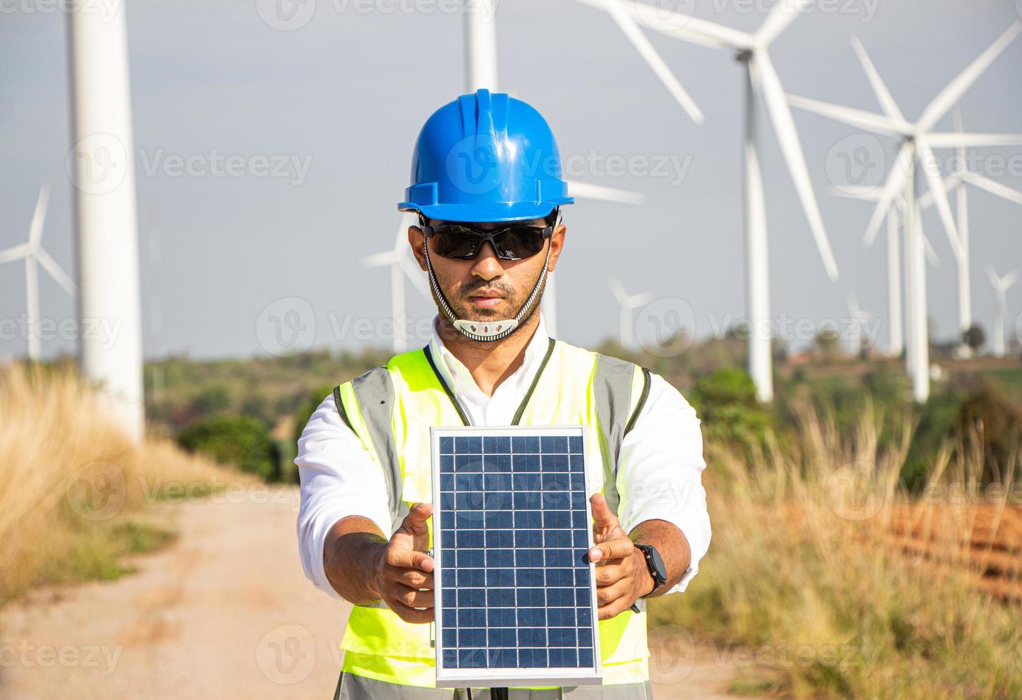 engineer team working in wind turbine farm and solar cell. Renewable energy with wind generator by alternative energy concept. photo