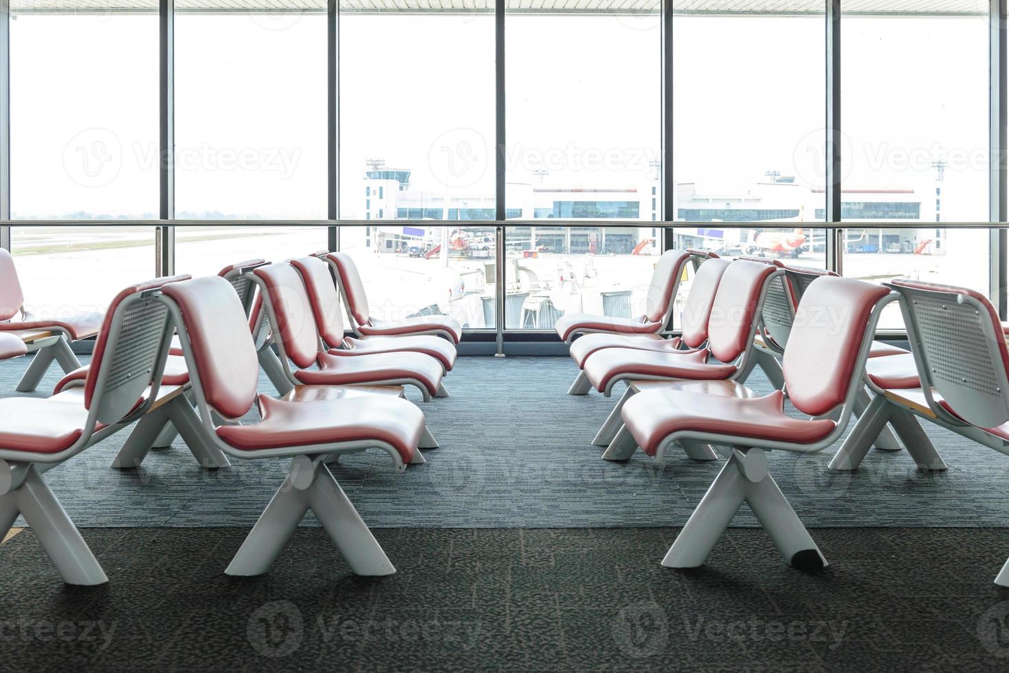 Departure lounge with empty chairs in the terminal of airport, waiting area photo