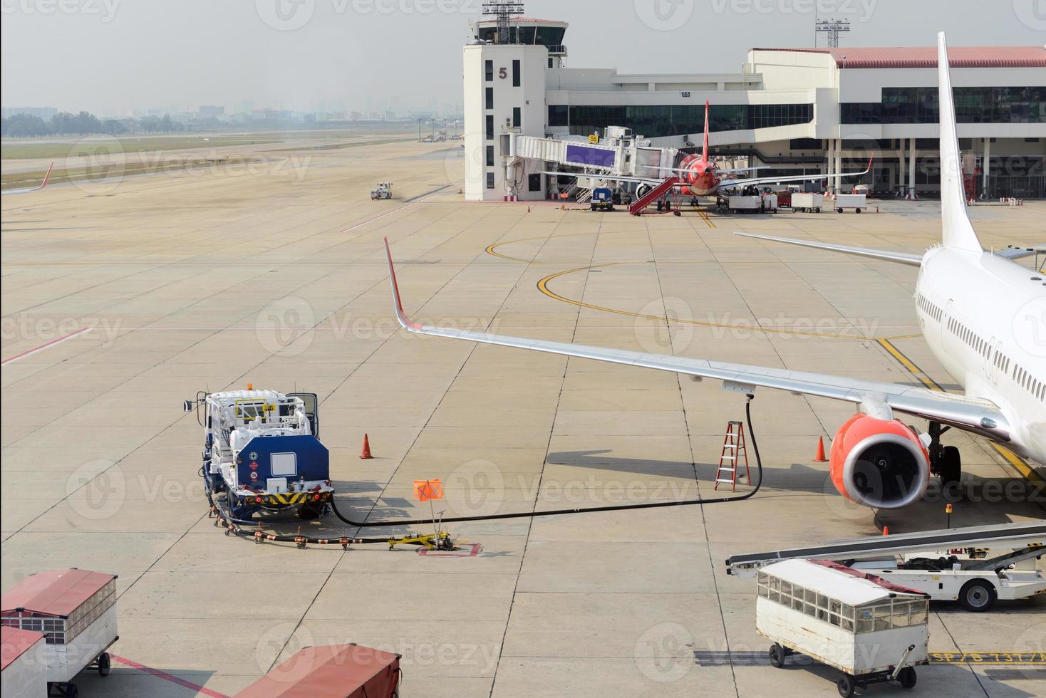 Airplane receiving fuel from tanker truck photo