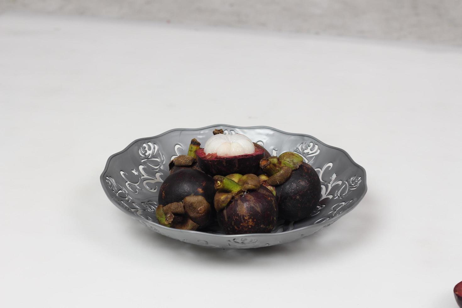 Mangosteen is a tropical fruit from Asia. Mangosteen has a distinctive sweet and sour taste. Mangosteen also has a myriad of benefits, properties, and nutritional content that is useful for health. photo
