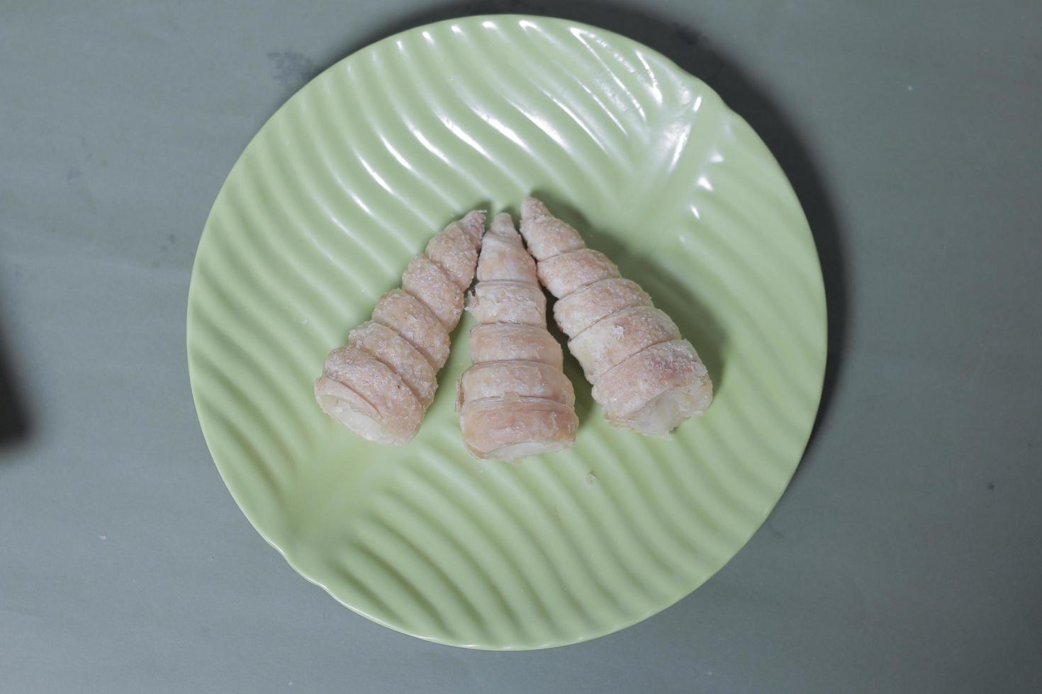 In Indonesia, this cake is known as cumcum cake. A cake shaped like a trumpet, or an ice cream cone. The perfect combination of a dry cake studded with sugar, plus a delicious cream vanilla filling. photo