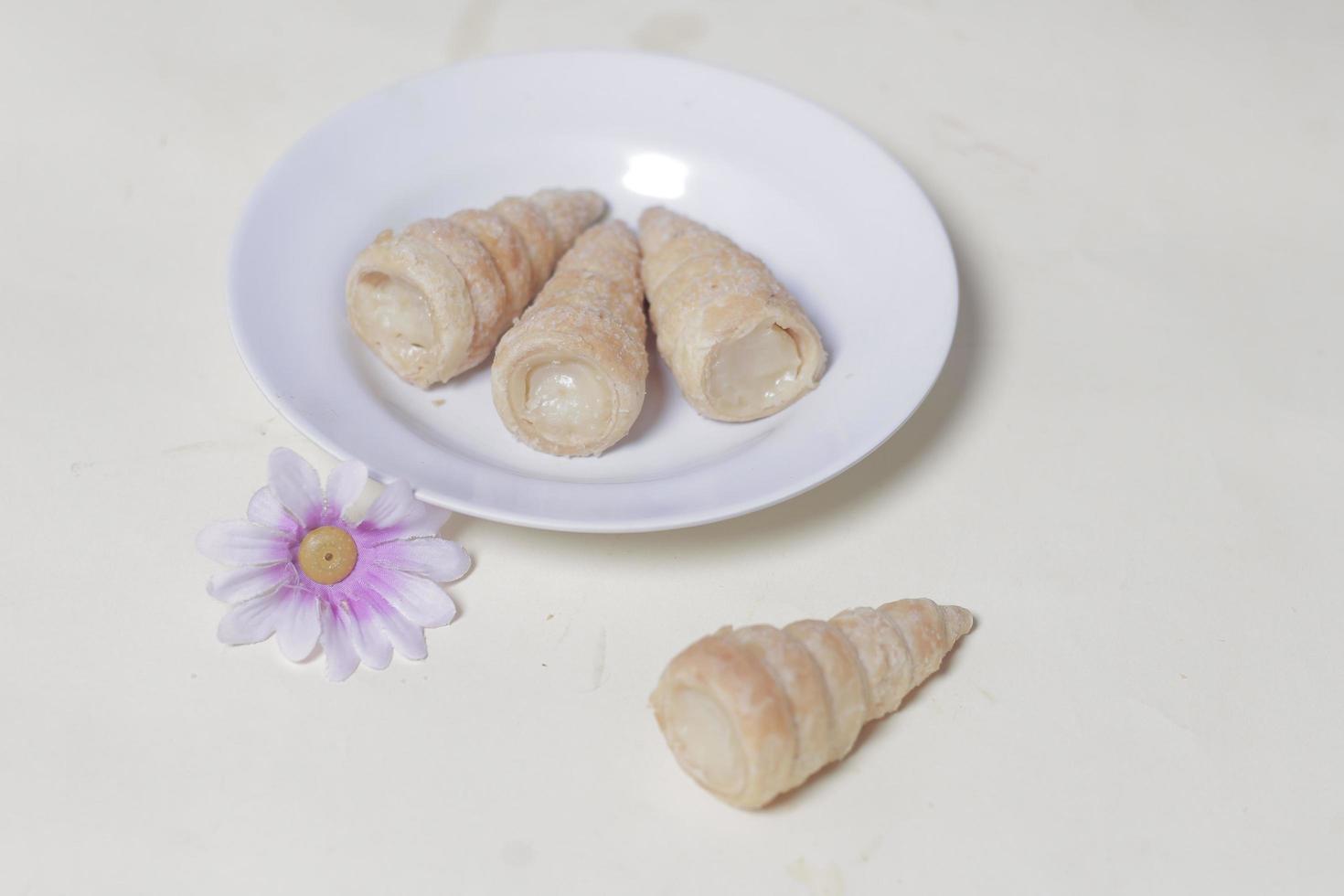 In Indonesia, this cake is known as cumcum cake. A cake shaped like a trumpet, or an ice cream cone. The perfect combination of a dry cake studded with sugar, plus a delicious cream vanilla filling. photo