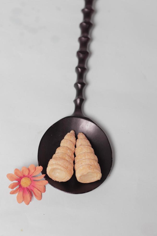 In Indonesia, this cake is known as cumcum cake. A cake shaped like a trumpet, or an ice cream cone. The perfect combination of a dry cake studded with sugar, plus a delicious cream vanilla filling. photo