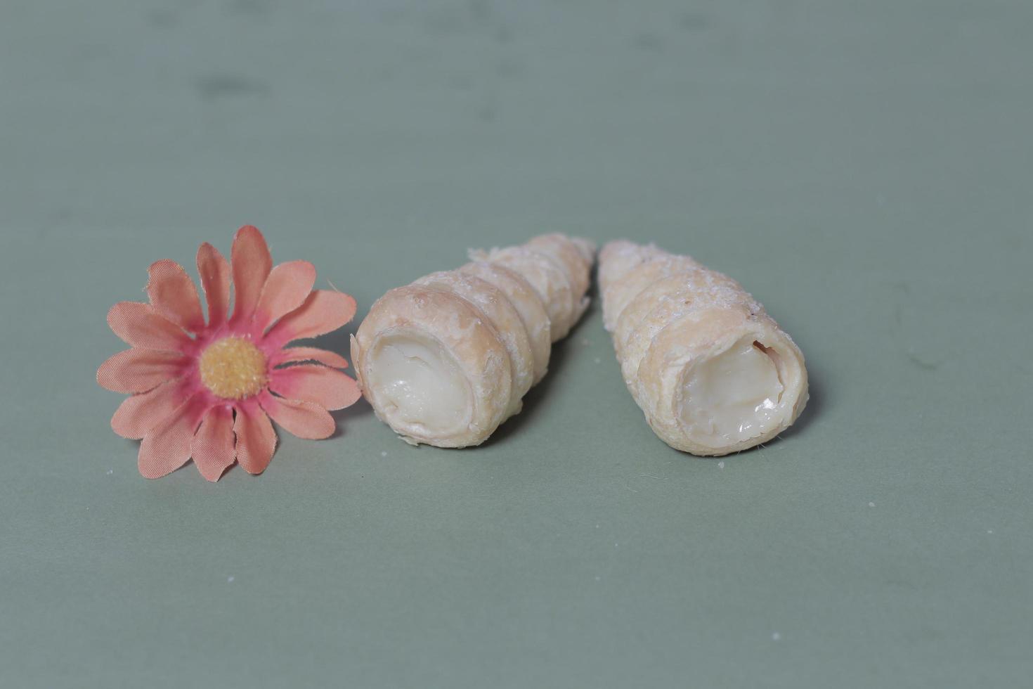 In Indonesia, this cake is known as cumcum cake. A cake shaped like a trumpet, or an ice cream cone. The perfect combination of a dry cake studded with sugar, plus a delicious cream vanilla filling. photo