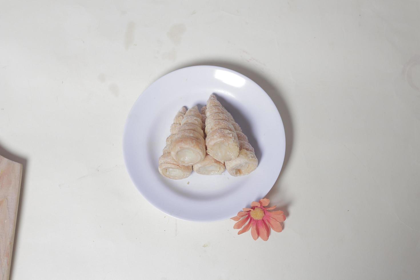 In Indonesia, this cake is known as cumcum cake. A cake shaped like a trumpet, or an ice cream cone. The perfect combination of a dry cake studded with sugar, plus a delicious cream vanilla filling. photo