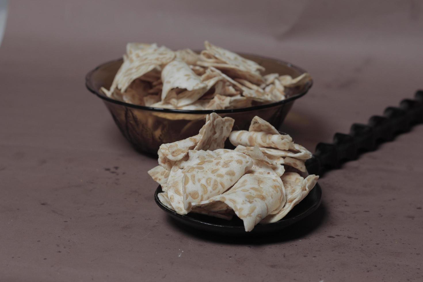Tempe chips is Indonesian snack made from fermented soybeans. slices of delicious and savory tempeh chips. soy chips are crunchy. These chips are suitable for snacks to accompany your relaxing time. photo