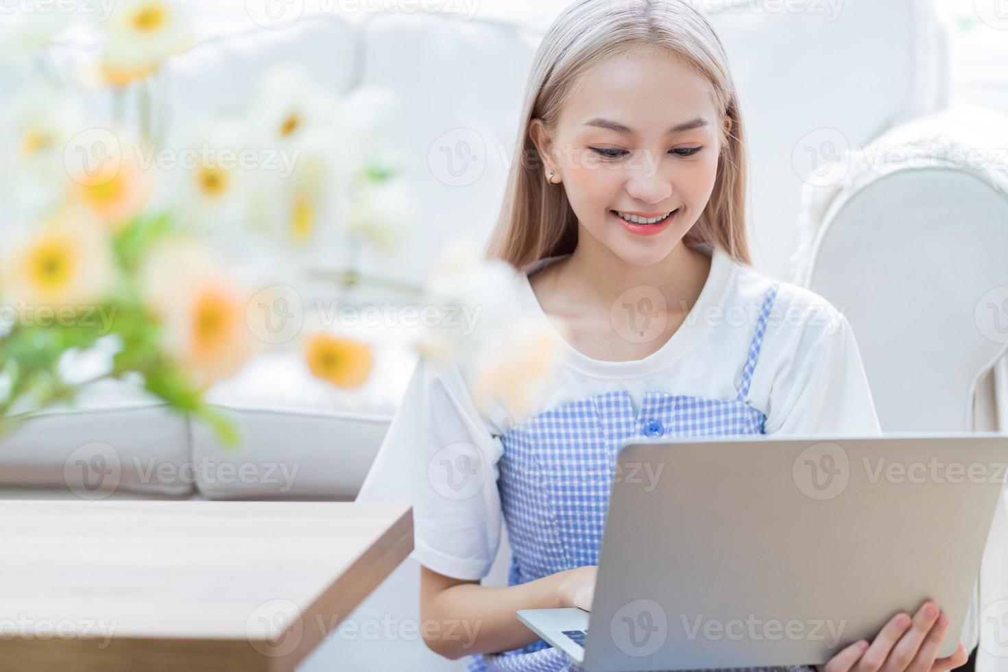 Young Asian girl using laptop at home photo