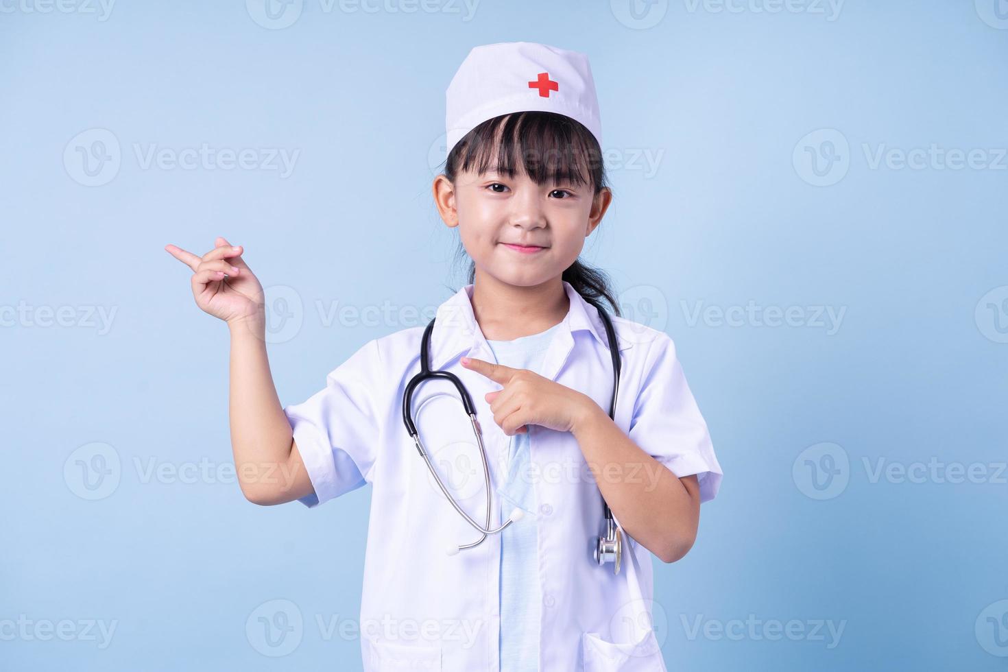 Image of Asian child wearing doctor uniform on blue background photo