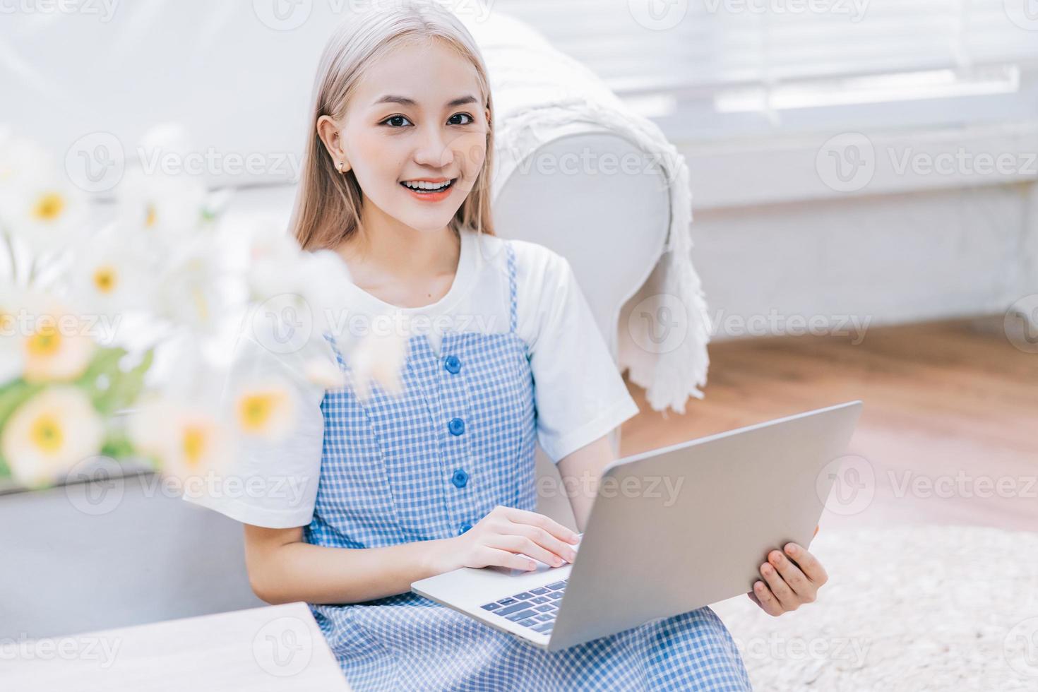 joven asiática usando laptop en casa foto