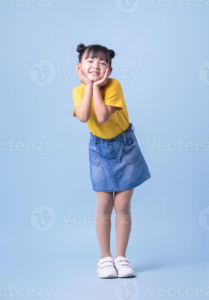 imagen de un niño asiático posando sobre fondo azul foto