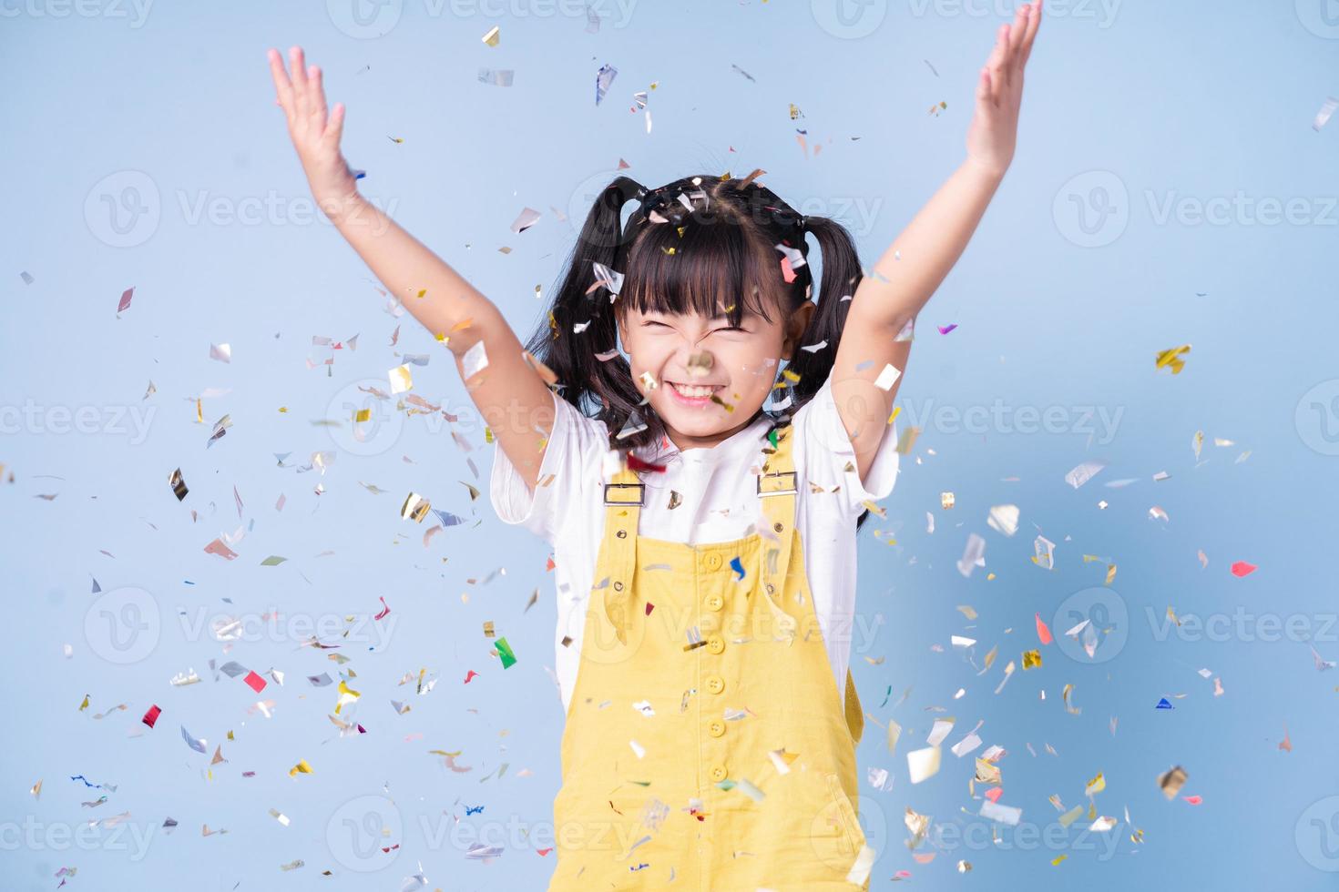 Portrait of Asian child posing on blue background photo