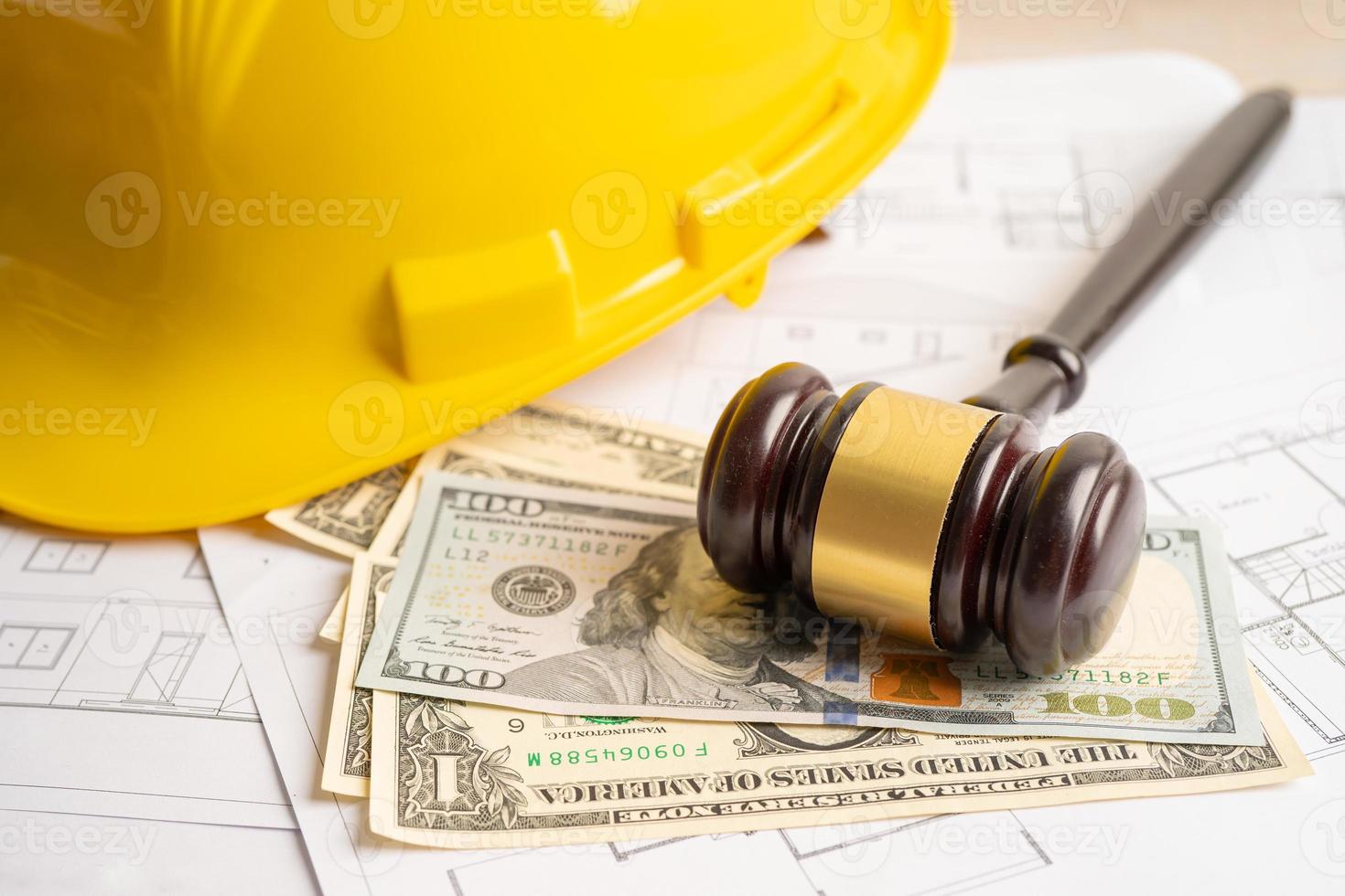 Architectural house plan project blueprint and Judge gavel hammer with yellow helmet and US dollar banknotes, Engineer and construction law and justice. photo