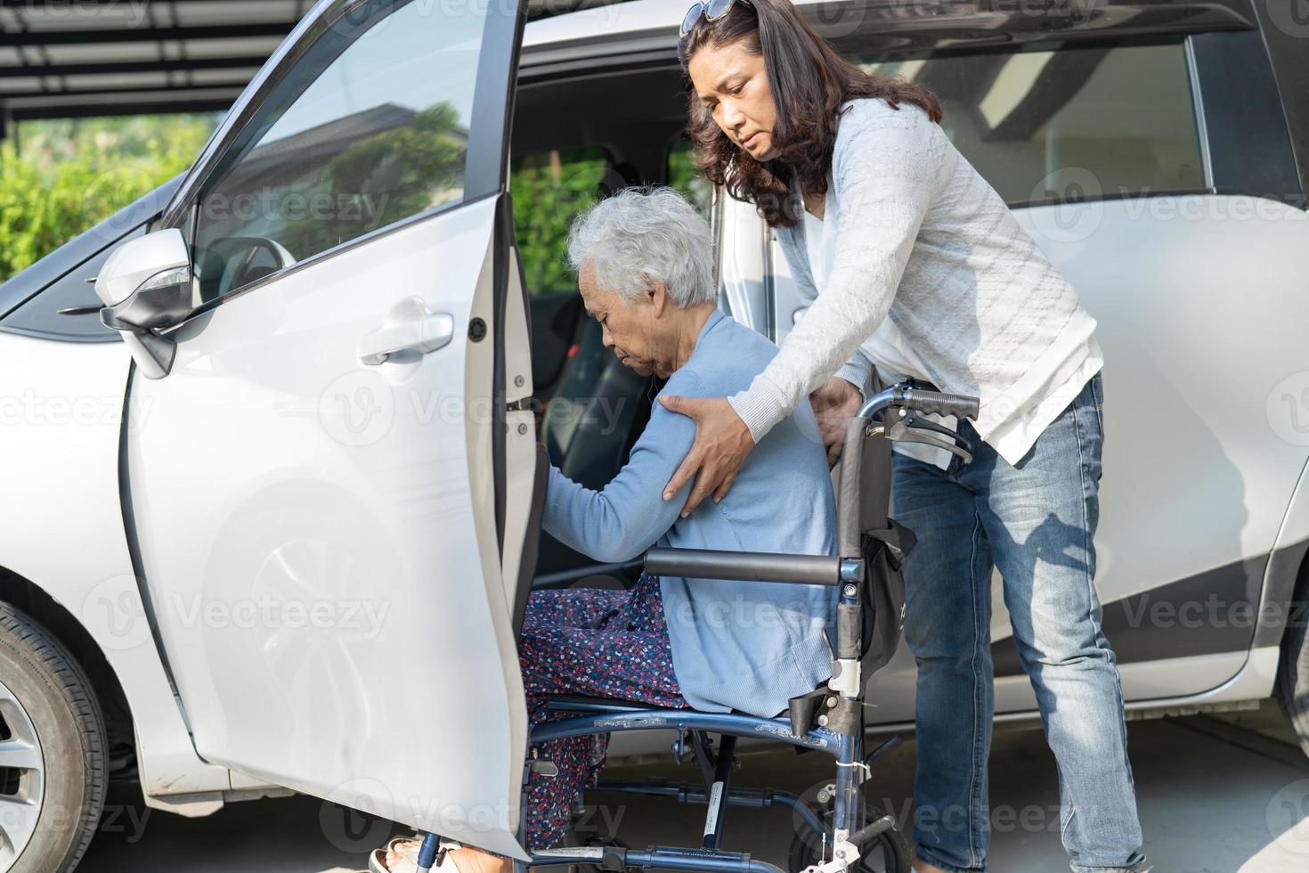 Asian senior or elderly old lady woman patient sitting on wheelchair prepare get to her car, healthy strong medical concept. photo