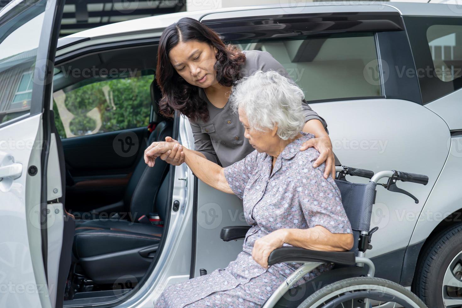 Ayudar y apoyar a la paciente asiática mayor o anciana sentada en una silla de ruedas prepararse para llegar a su automóvil, concepto médico fuerte y saludable. foto